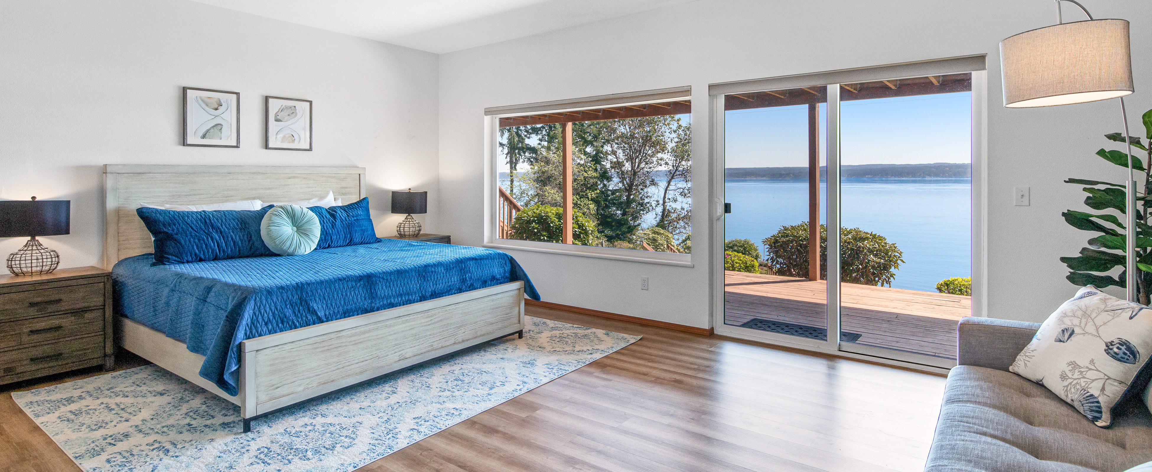 A spacious bedroom of a Brinnon, WA vacation rental with hardwood floors and a view of the ocean.