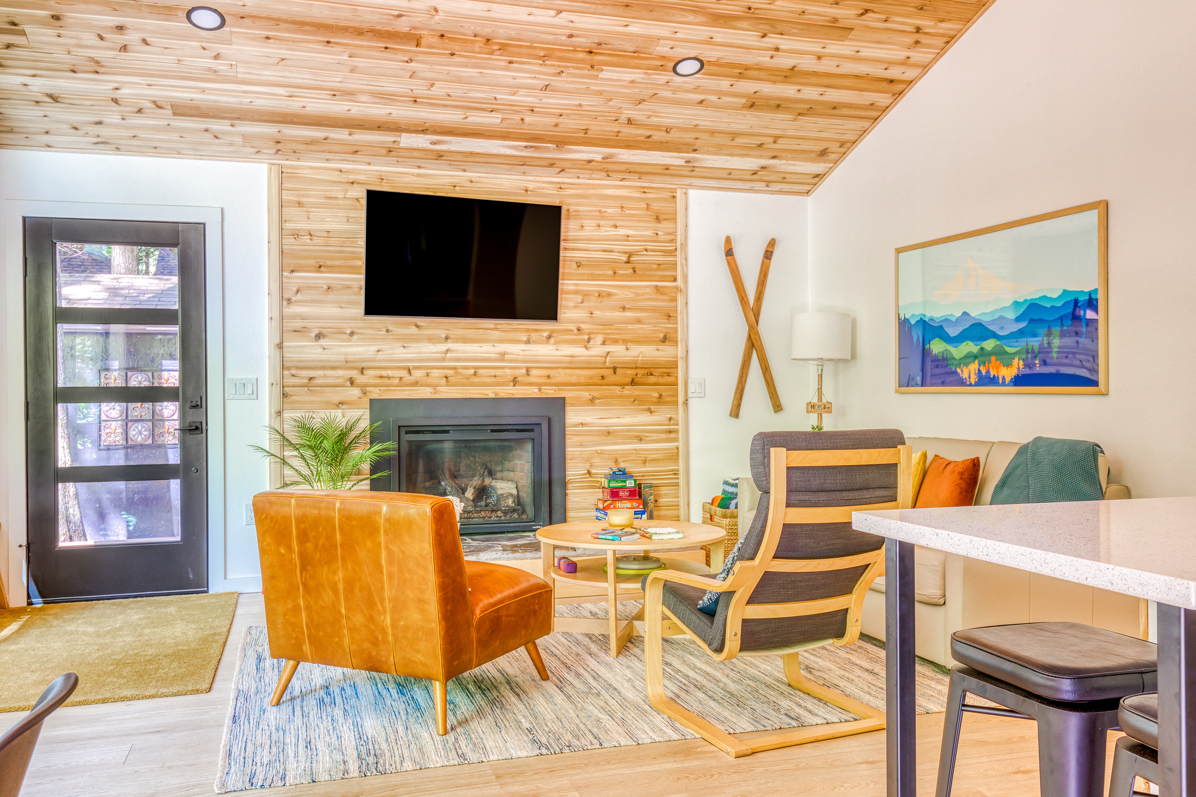 bright modern living space with mounted TV, fireplace, cozy seating, and a coffee table