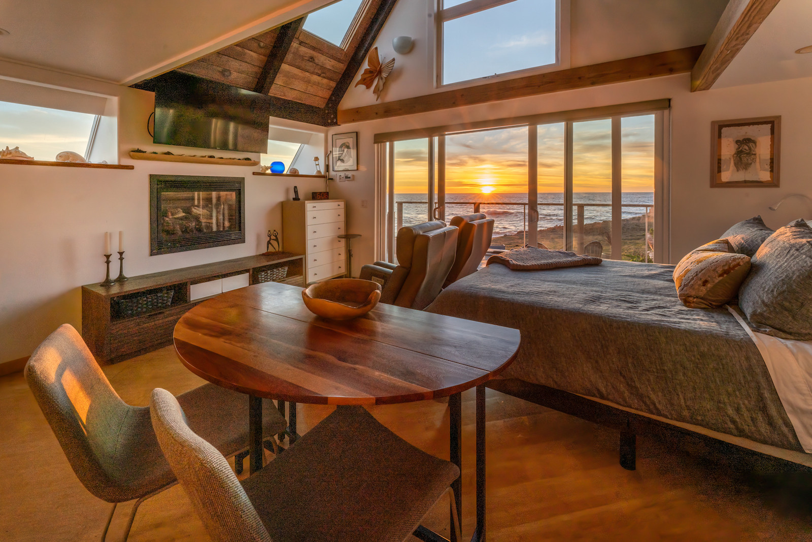 A studio with a bedroom and table at a vacation rental in Fort Bragg as pictured during sunset.