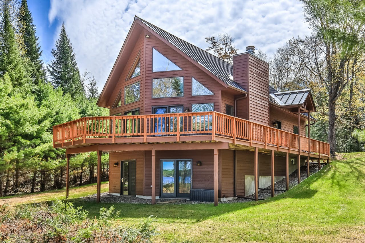 St. Germain, WI cabin rental in a forest with a beautiful green lawn.