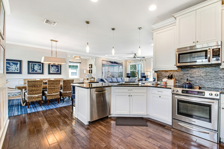 View from full kitchen into open-concept dining and living area with modern countertops