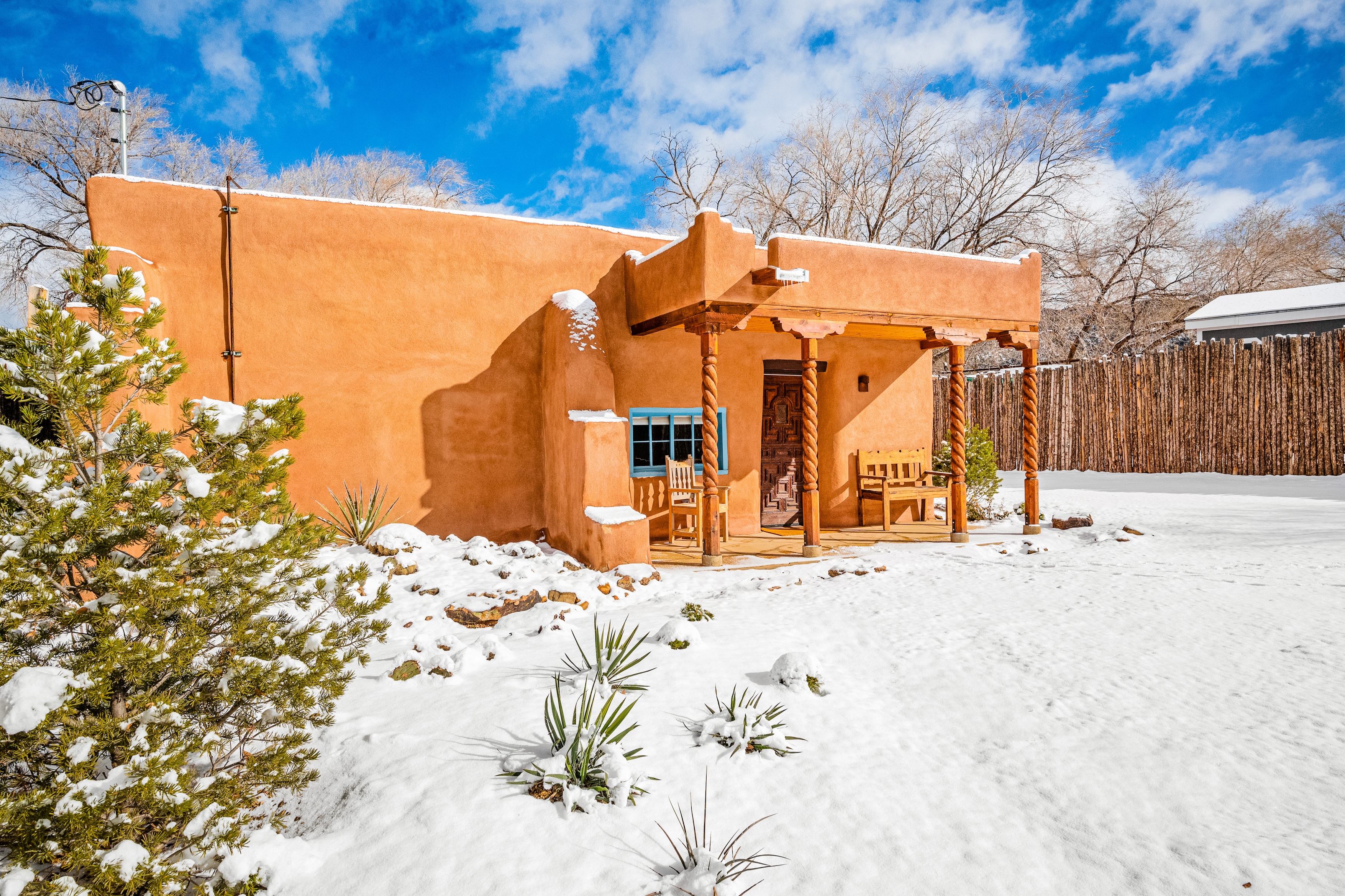 an adobe home in taos surrounded by snow in winter