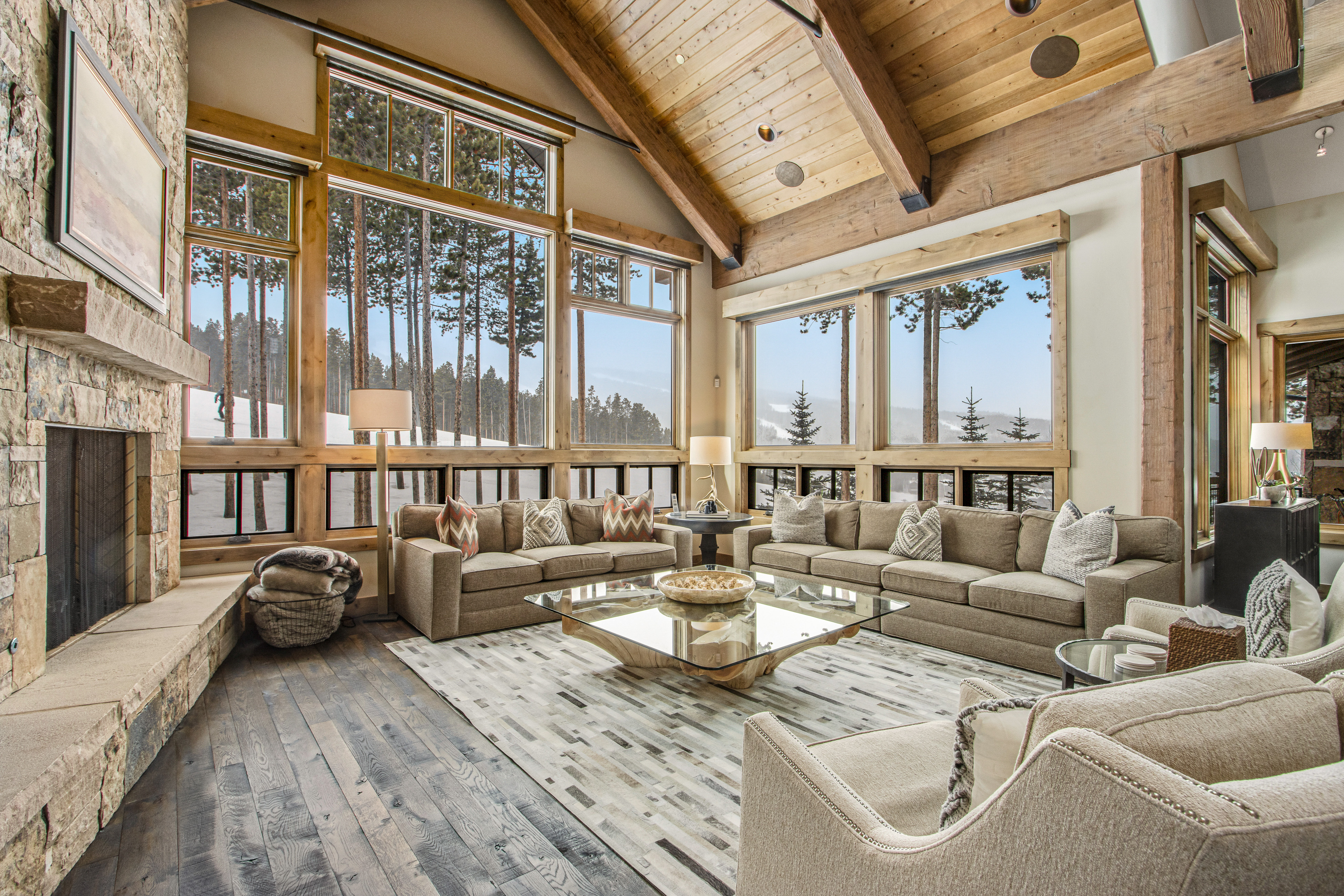 large living space with big couches and huge windows with snow covered mountain views