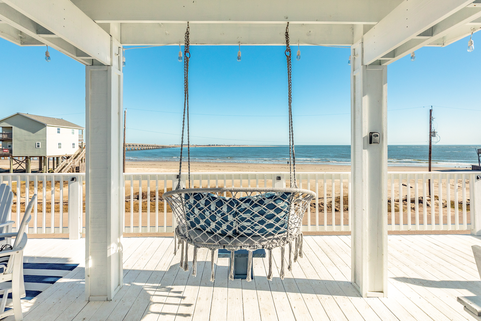 The balcony with a hanging chair overlooking the bay at a Freeport, Texas vacation rental.