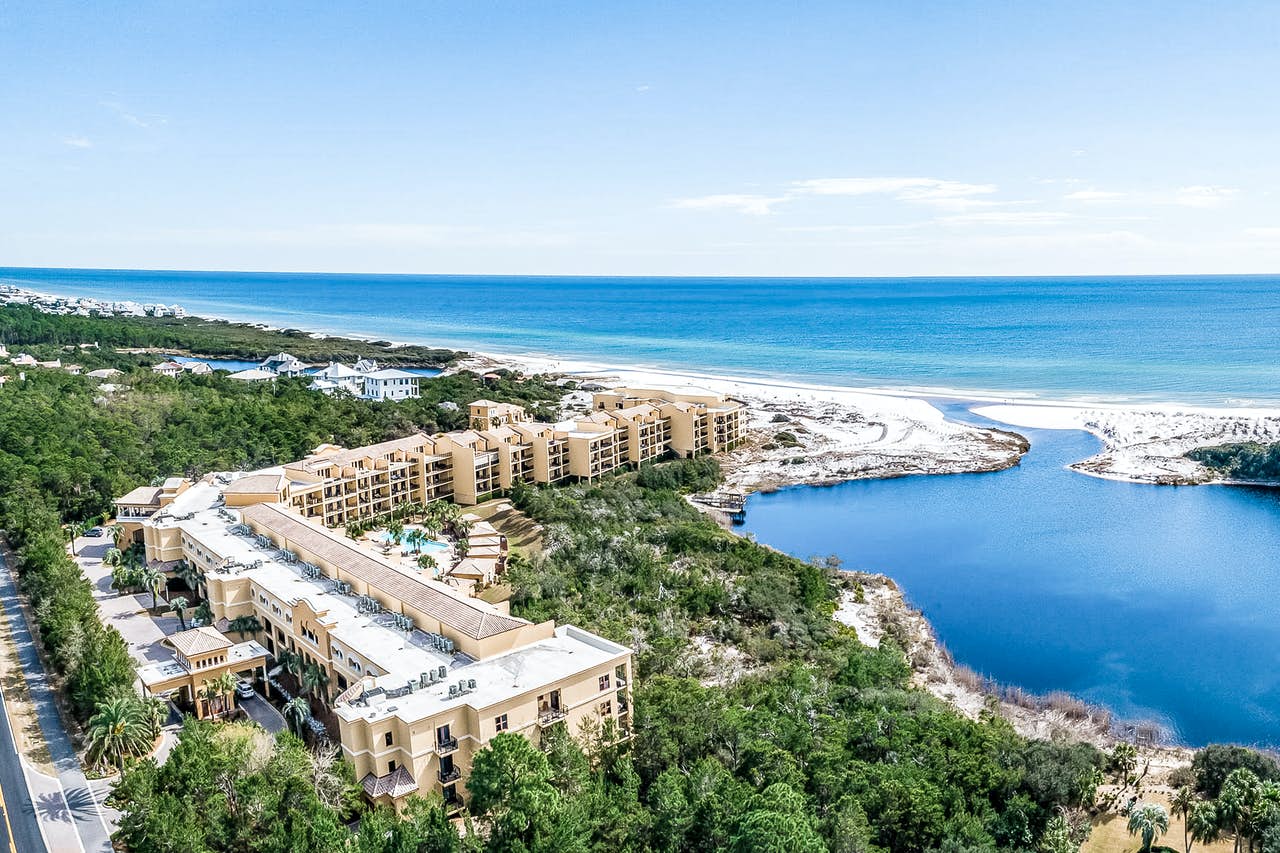 A condominium complex in Santa Rosa Beach, FL by the ocean with an inlet to a bay.
