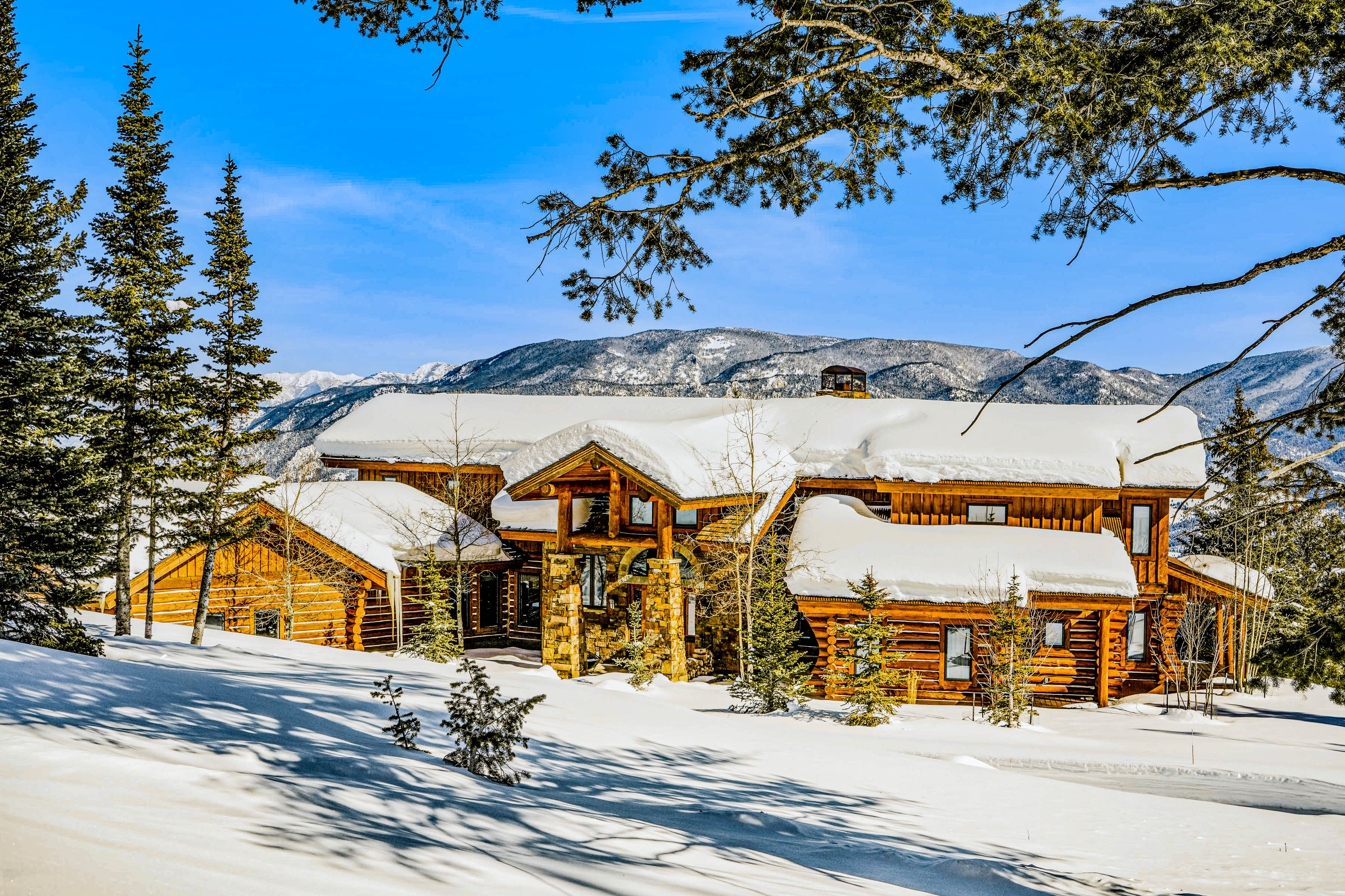 luxury lodge in big sky with snow-covered mountains in the background