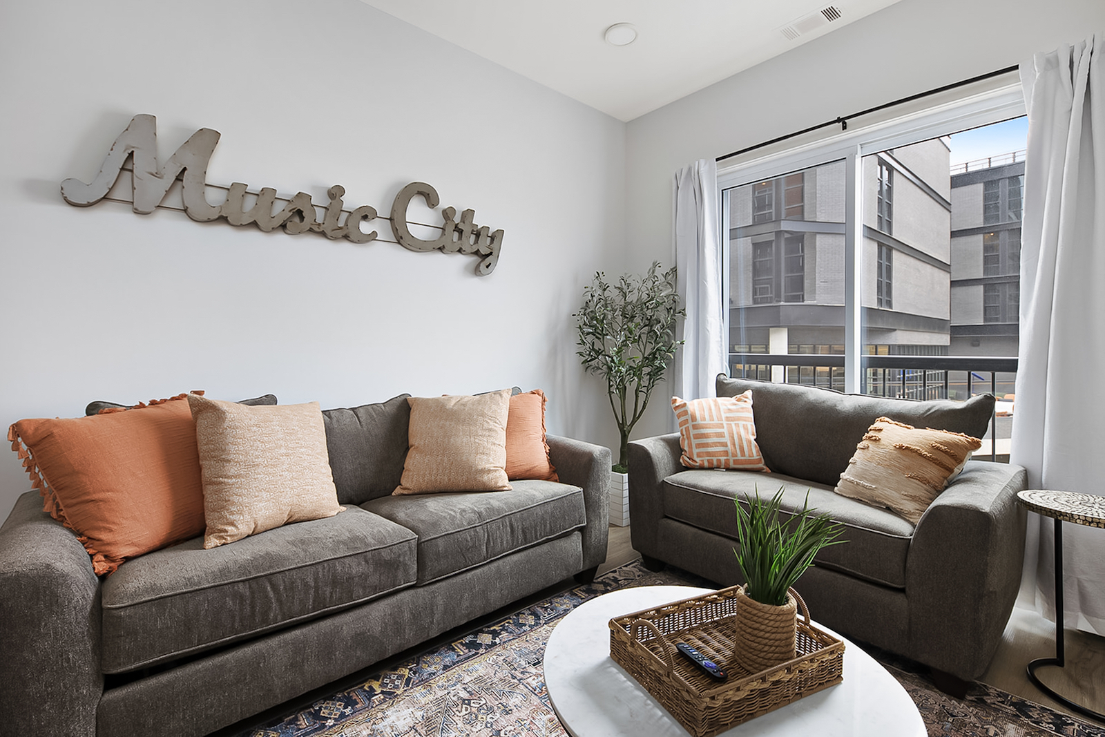The living room of a vacation rental in Nashville, TN with a sign reading "music city" over the couch.