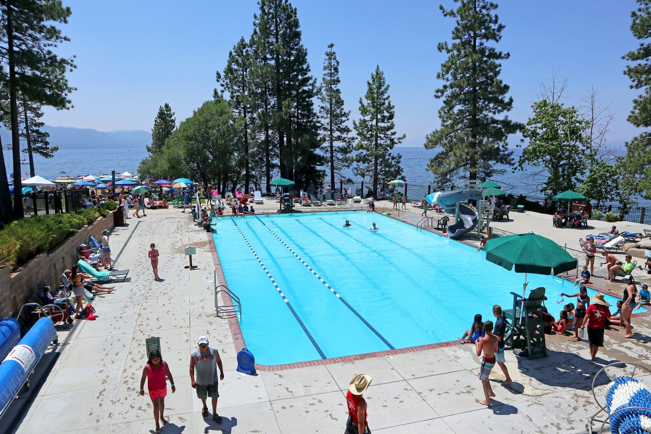 Large public pool with swim lanes and people enjoying their time at Lake Tahoe.