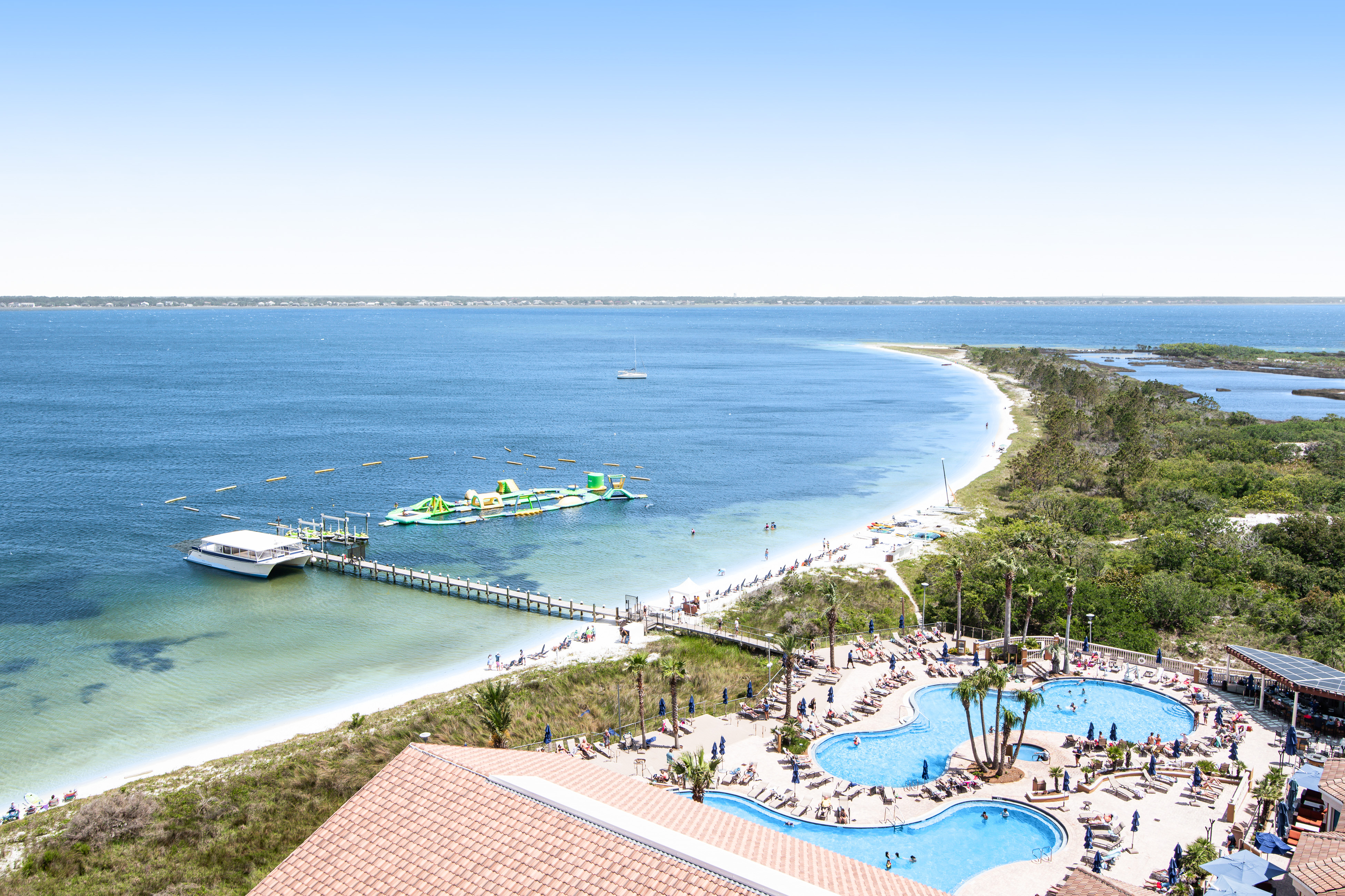View of resort pools and pier over the Gulf in Pensacola Beach, FL