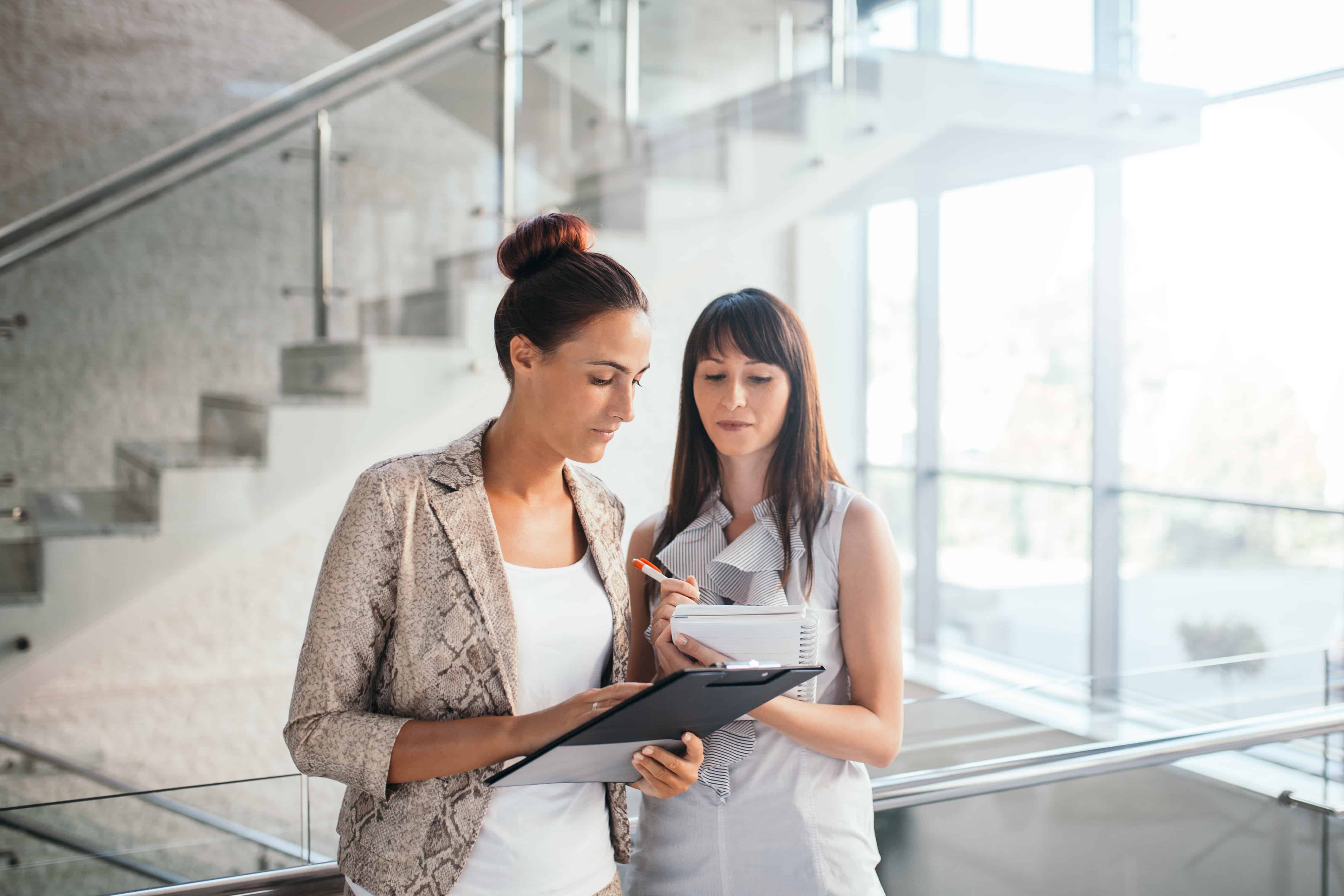 Two people looking over documents and taking notes