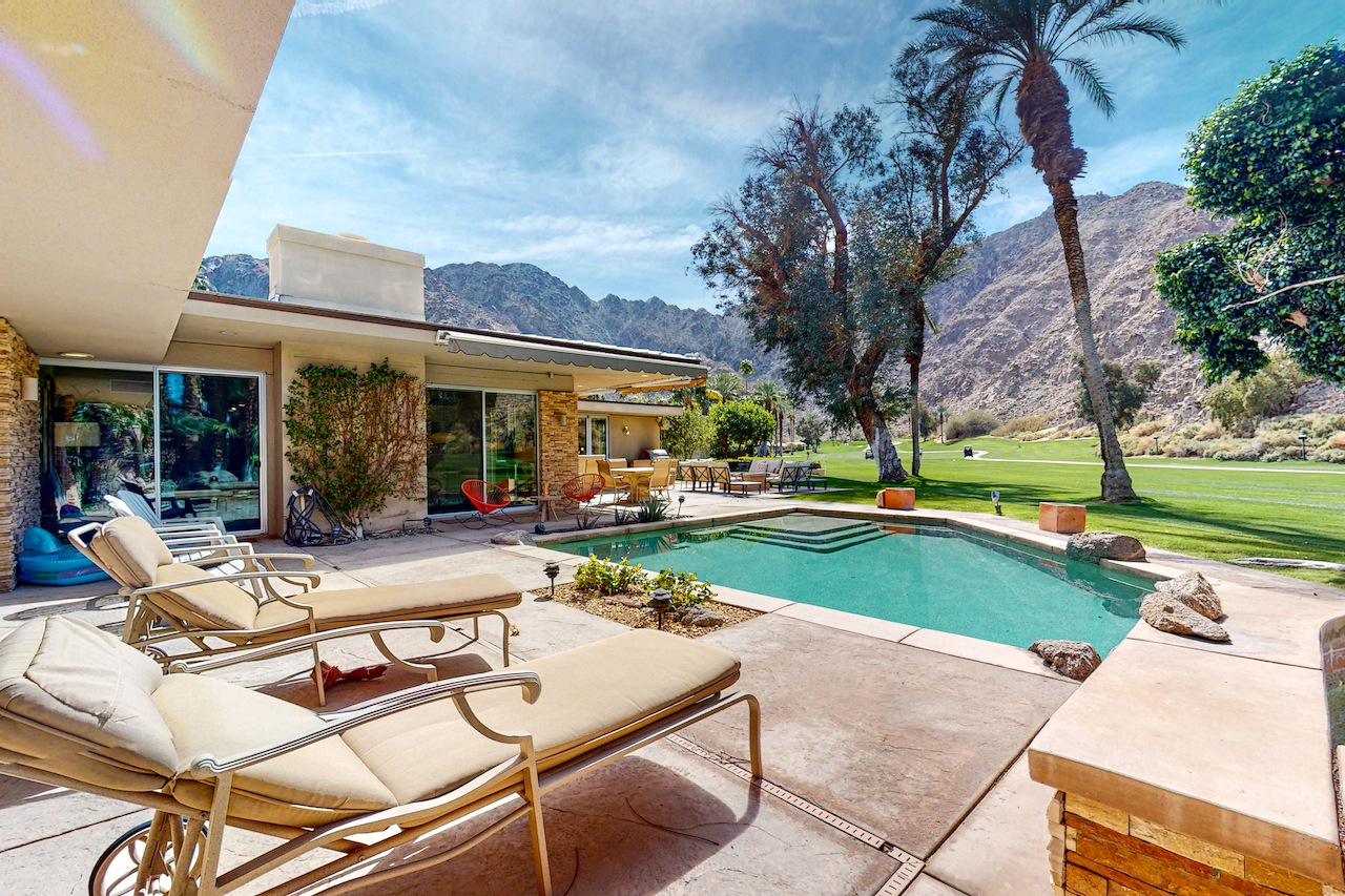 The pool area of a vacation rental in Indian Wells, CA overlooking the golf course.