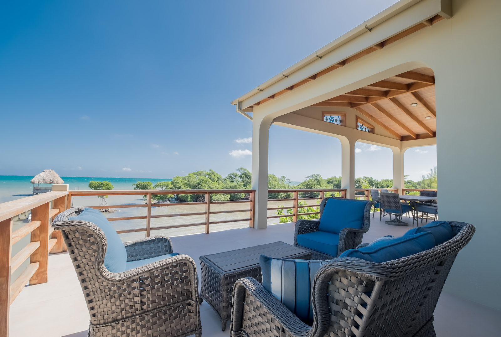 The patio with chairs and a table overlooking the beach at a vacation rental in Belize.