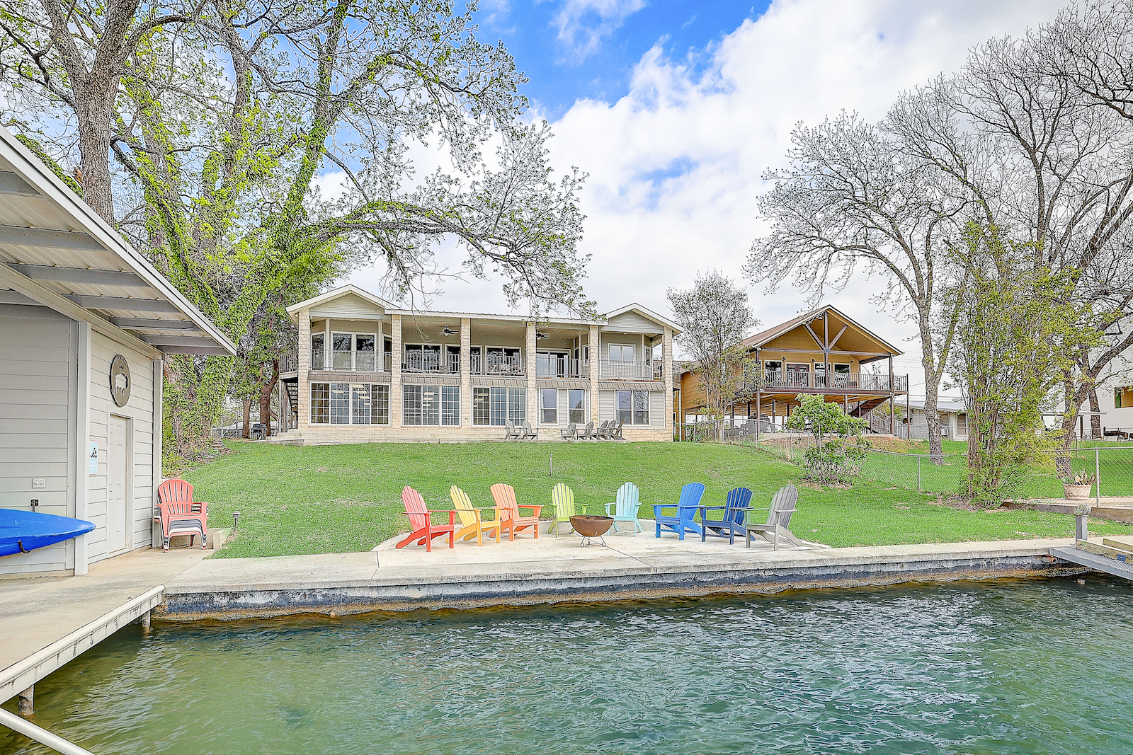 The dock area lined with colorful chairs and the back area of a vacation home in Kingsland, TX.