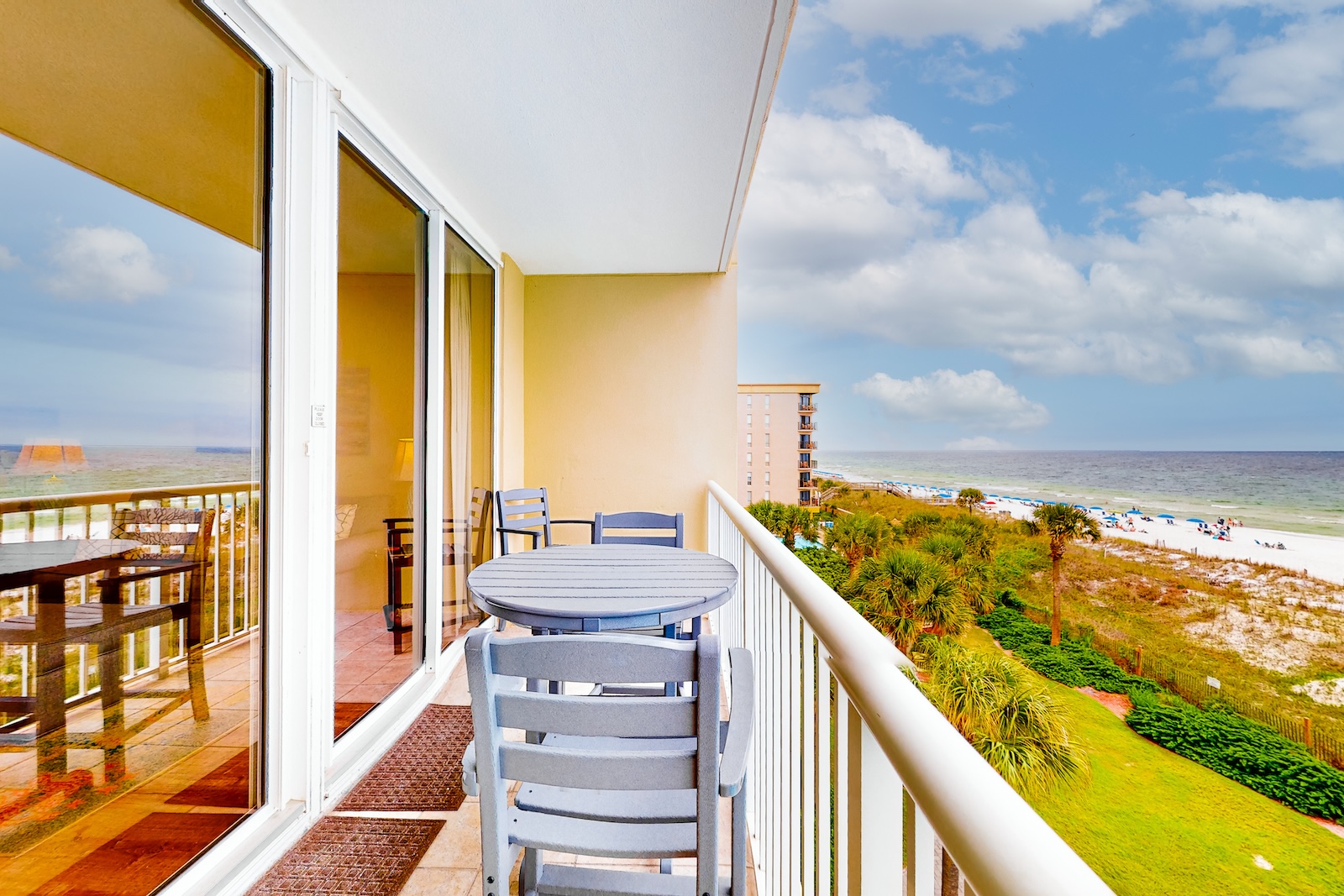 The deck of a vacation rental with a table and chairs overlooking the coast in Fort Walton Beach, Fl.