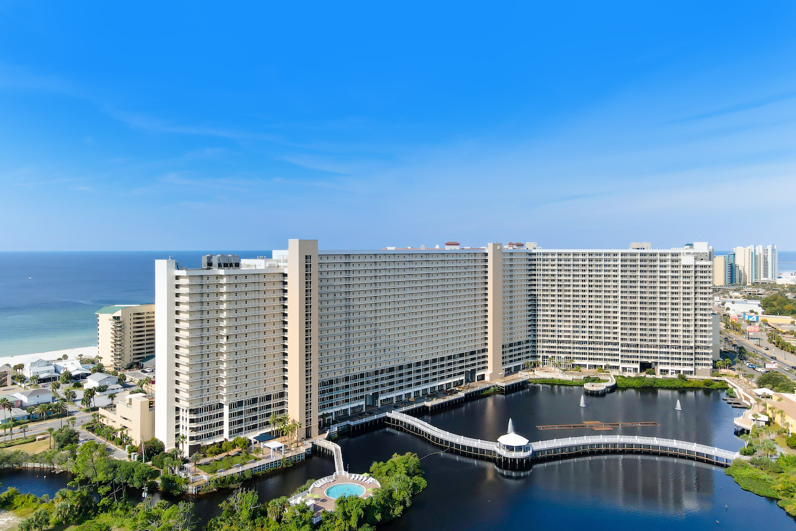 Image of a condo building in Florida with a water feature and bridge.
