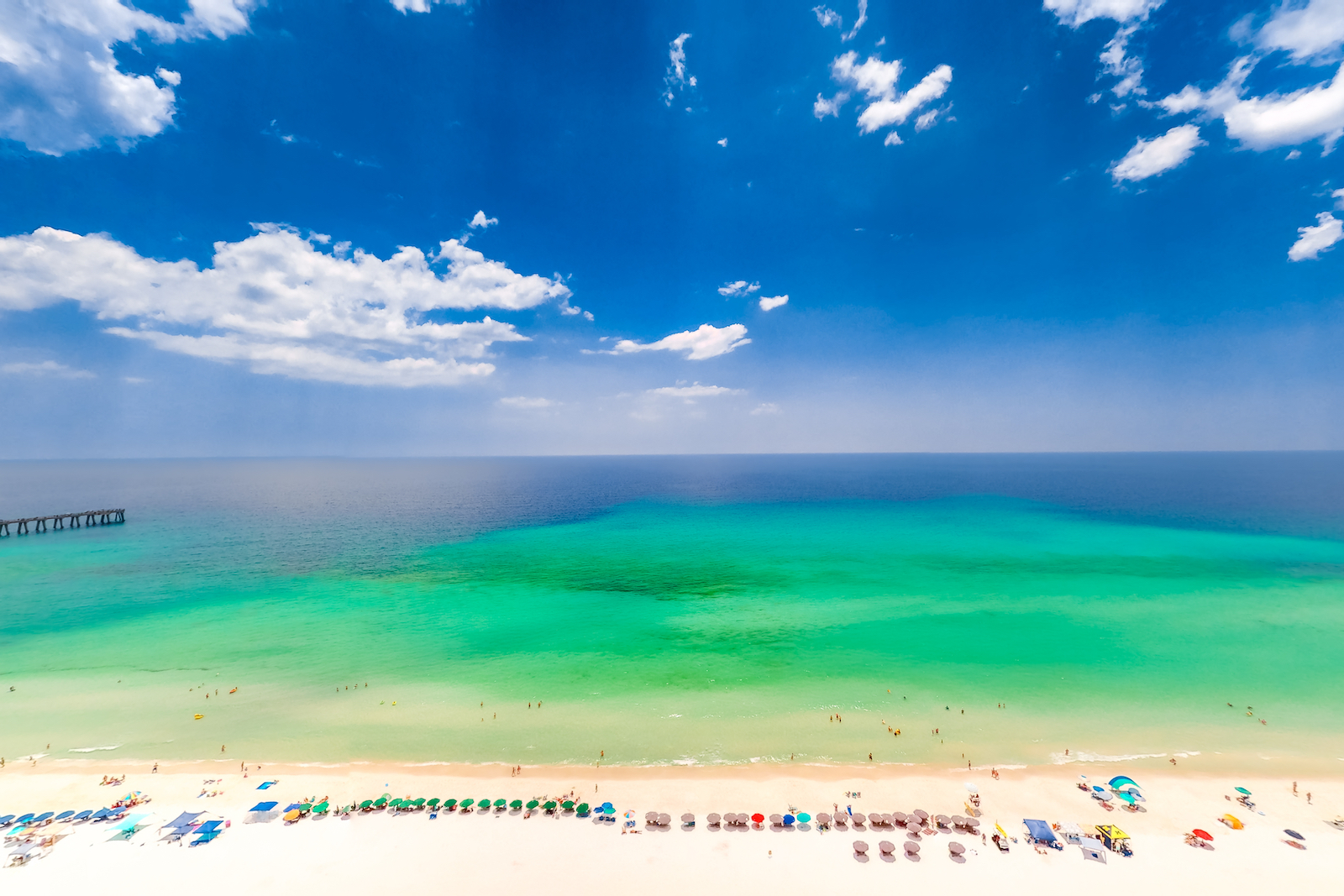 Birds eye view of Navarre Beach with a coastline of tourists enjoying the ocean.