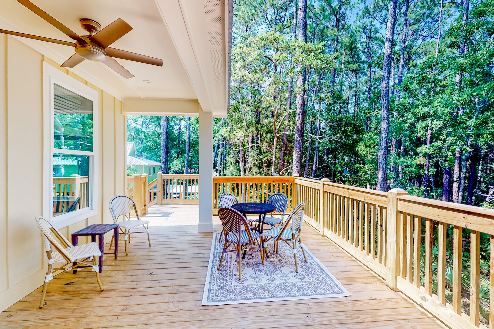 The deck with tables and chairs at a Dauphin Island vacation rental.