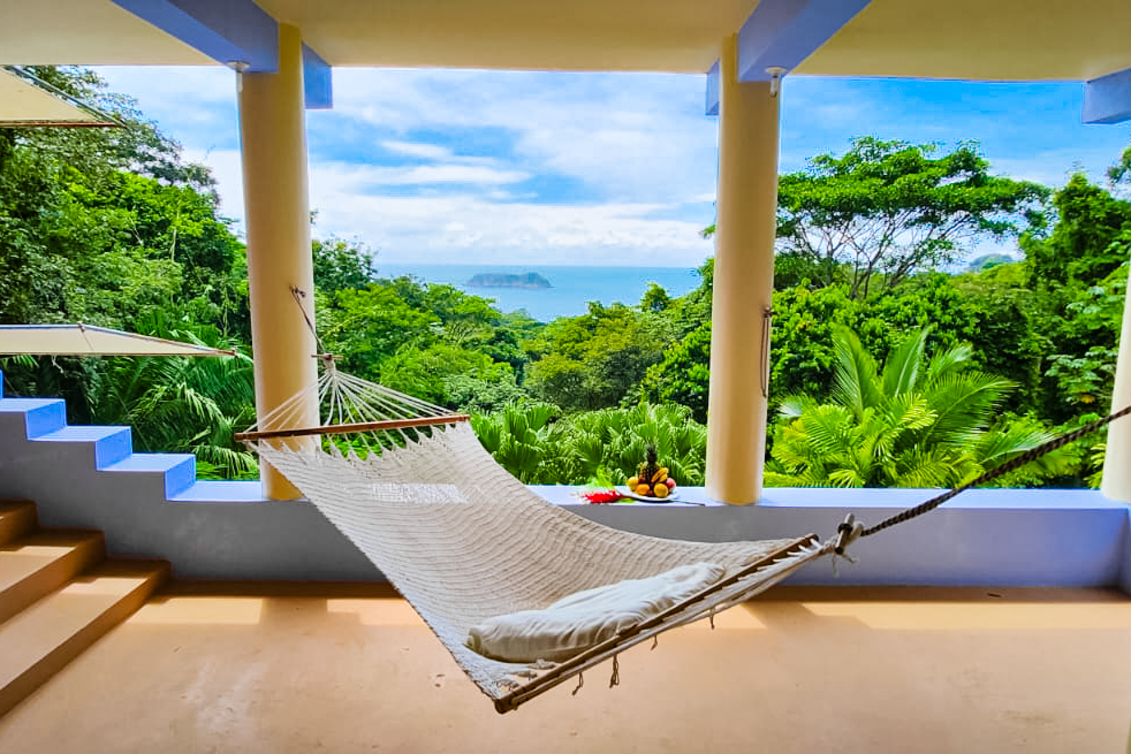 costa rica home with hammock hanging on back patio with an incredible view