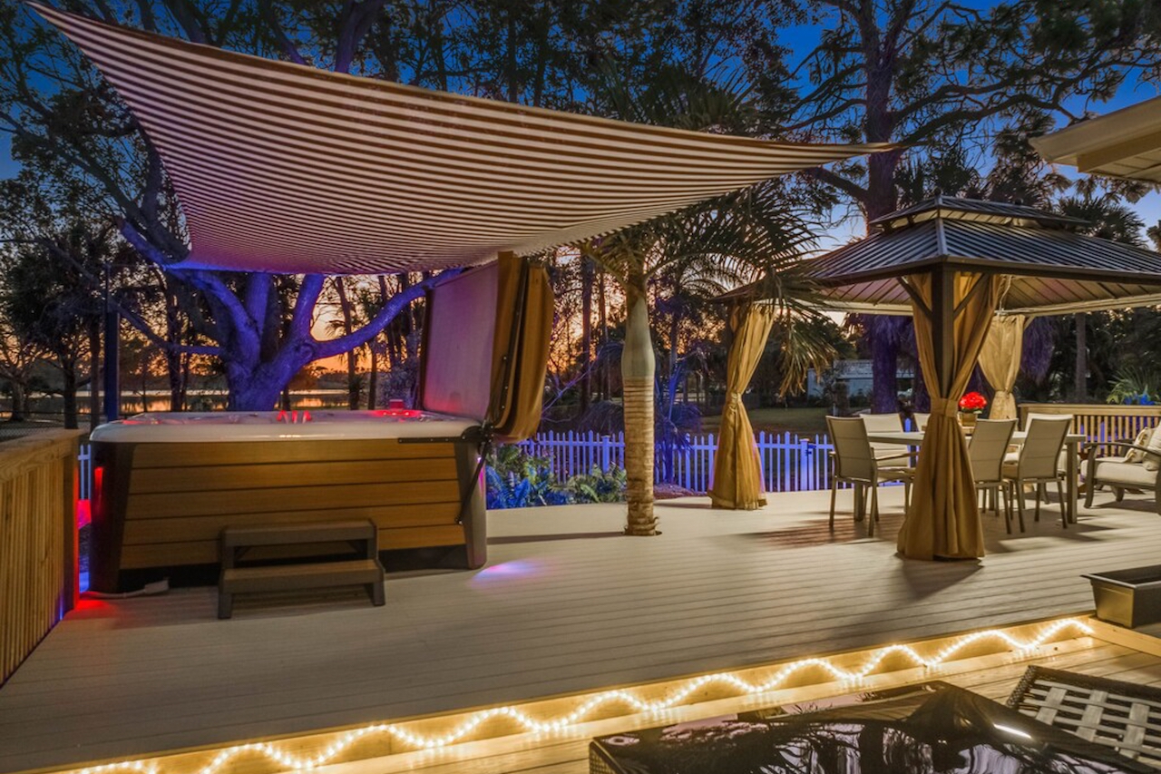 The back patio overlooking the lake with a hot tub at a vacation rental in Naples, FL.