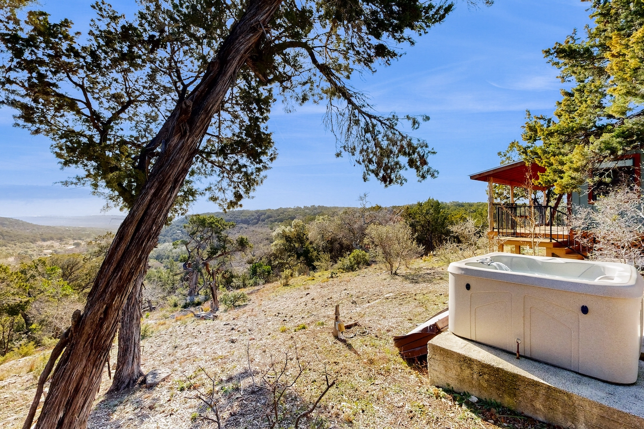 The hot tub area overlooking the scenery of Central Texas at a short term rental in Wimberley, TX.