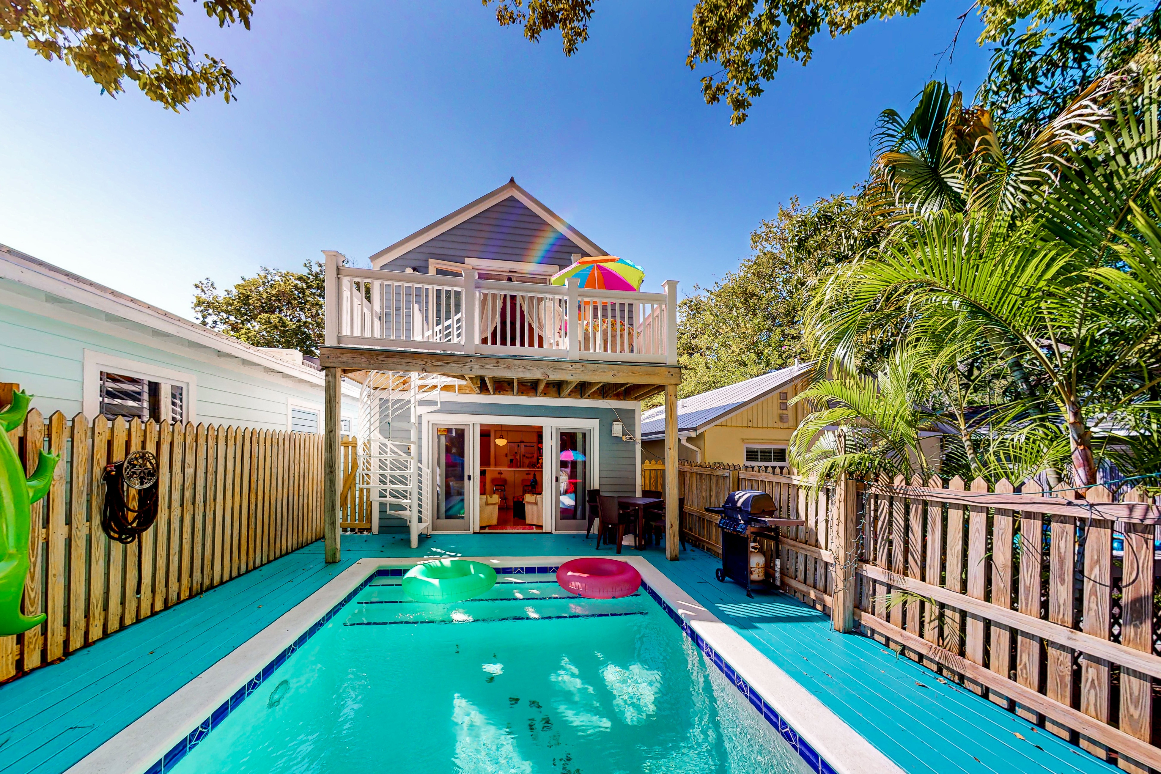 private pool of two level vacation home with upper deck and a spiral staircase to pool area