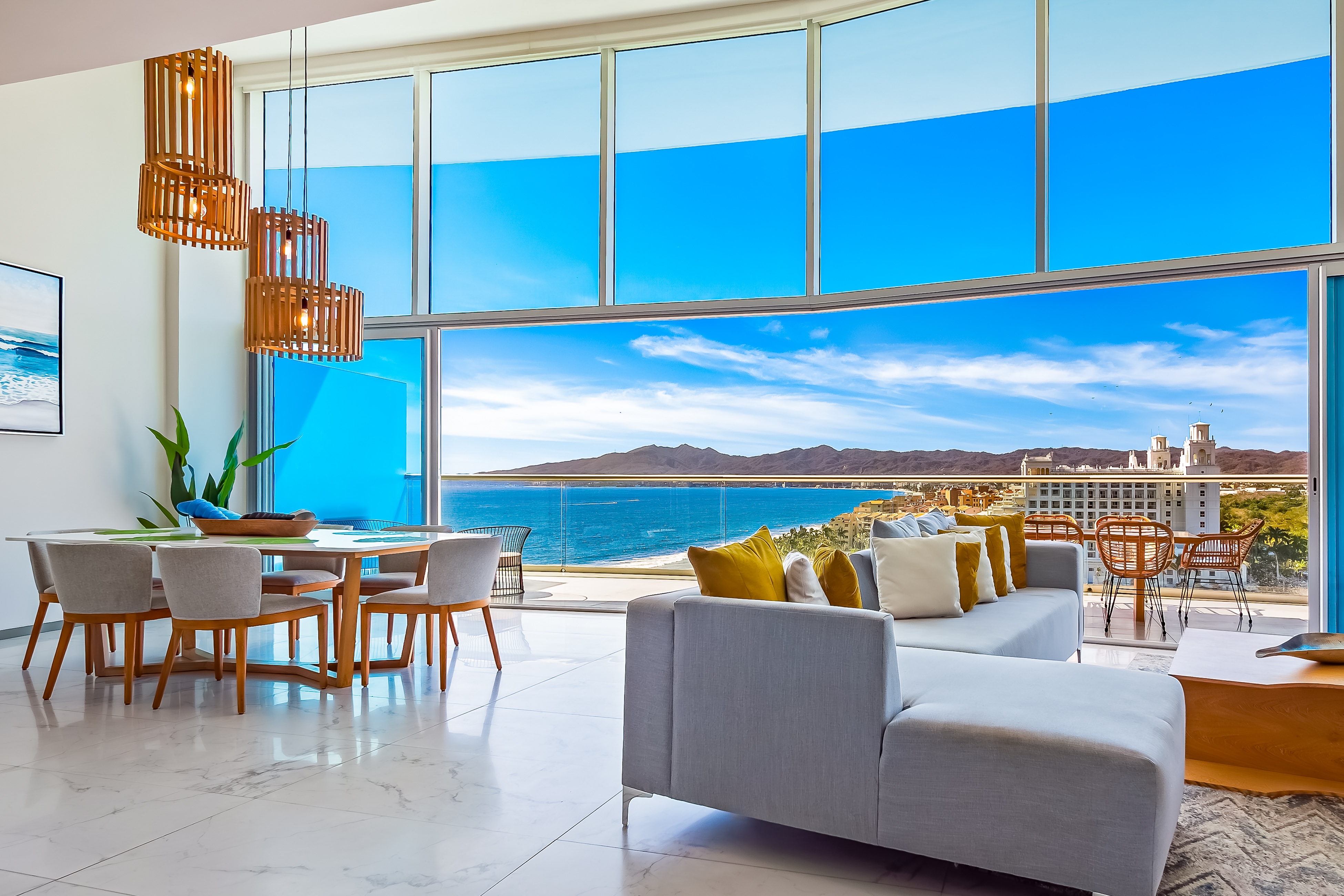 floor to ceiling windows of modern condo overlook the ocean and beaches in mexico