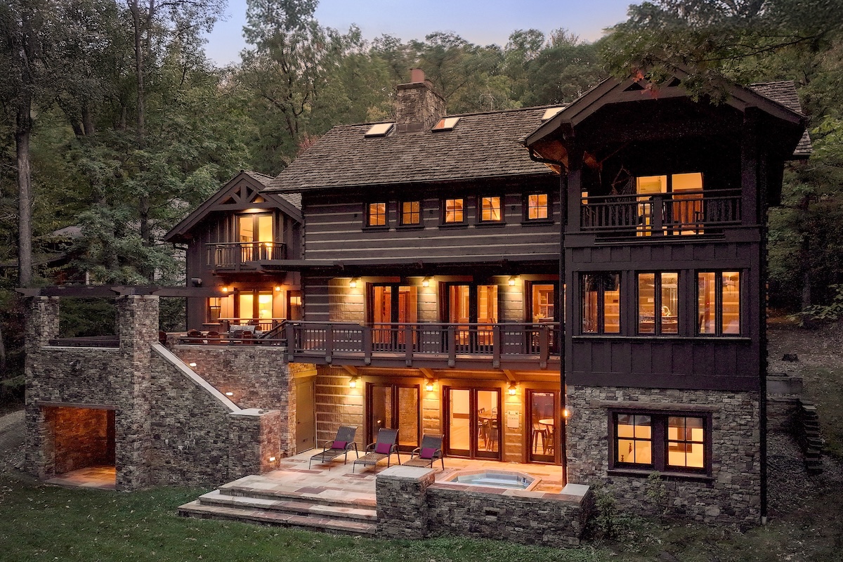 The exterior of a cabin with a hot tub.