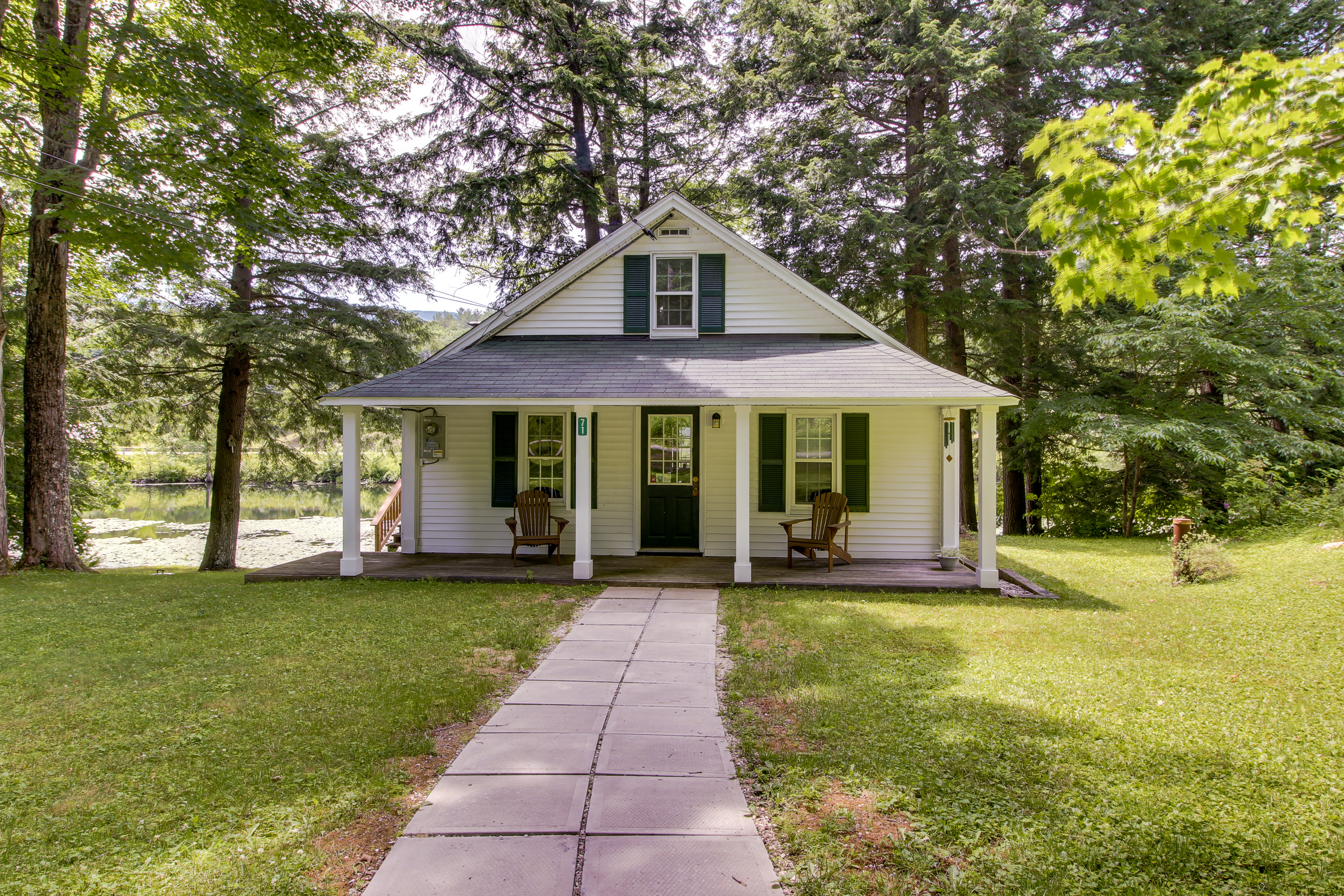 waterfront cottage in ludlow, vermont with blue shutters and a covered patio