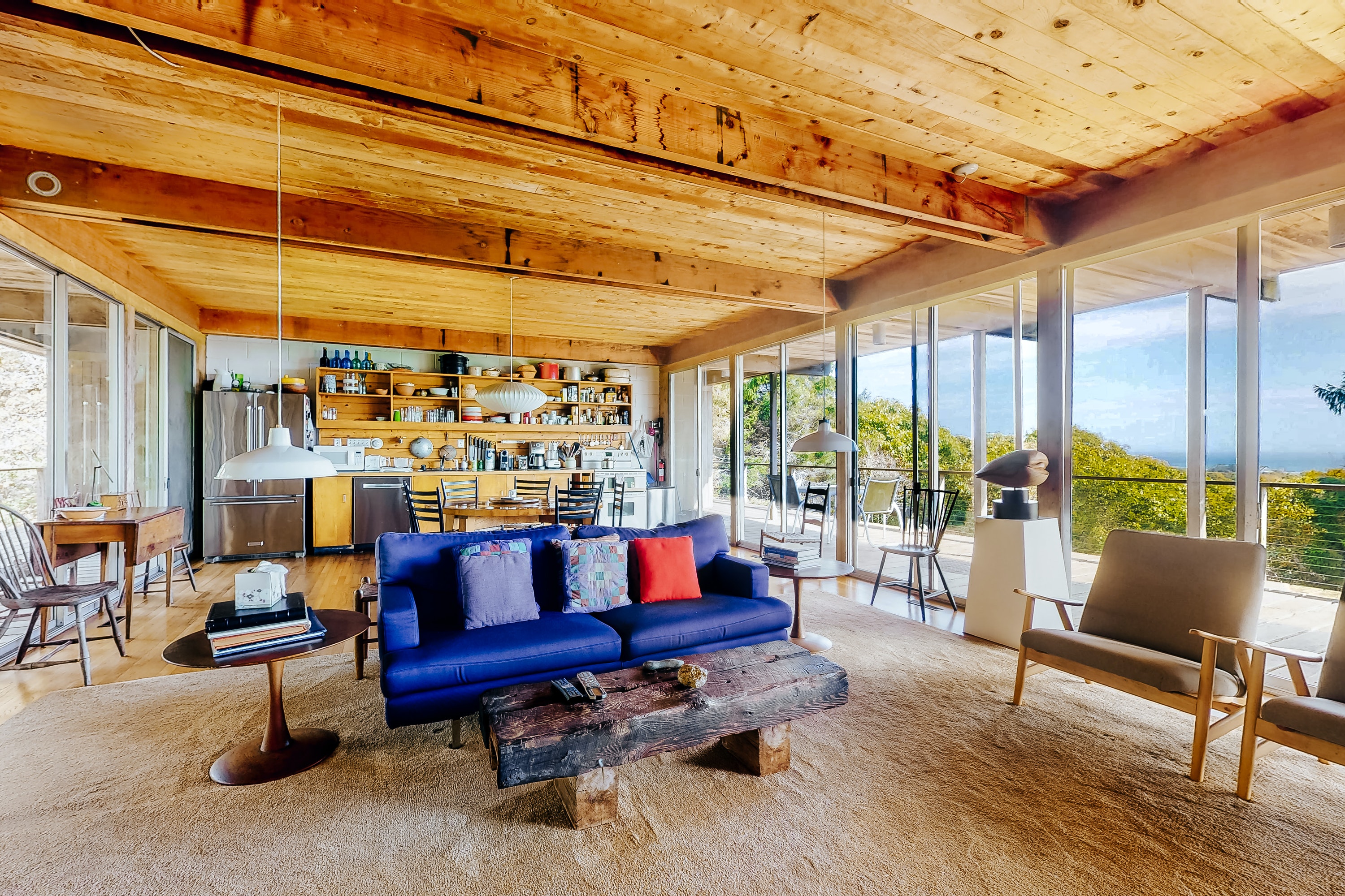 Exposed wood beams and open layout with a blue coach and beautiful views in Chilmark, MA.