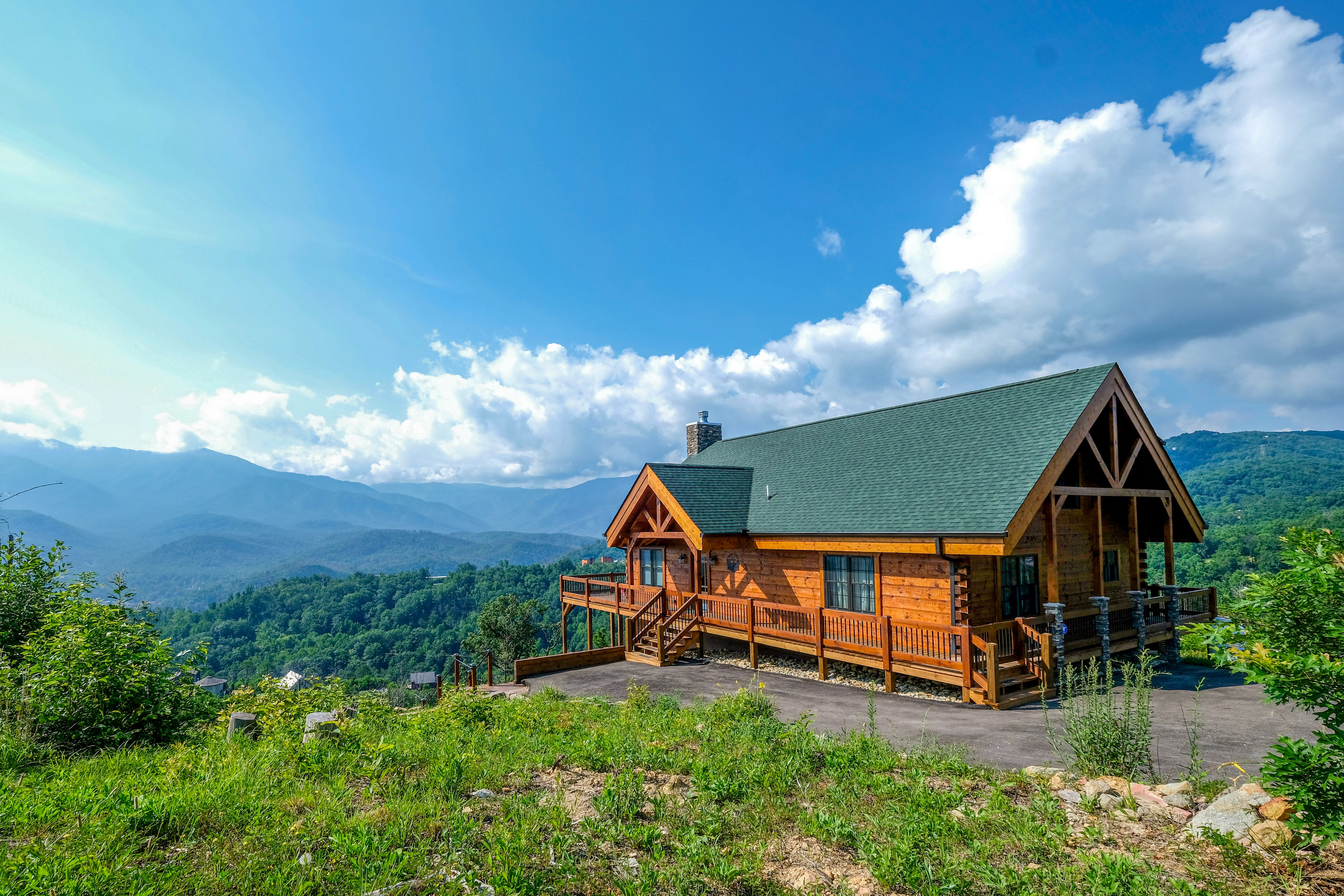 a cabin overlooking a beautiful view of the smoky mountains in gatlinburg on a sunny summer day