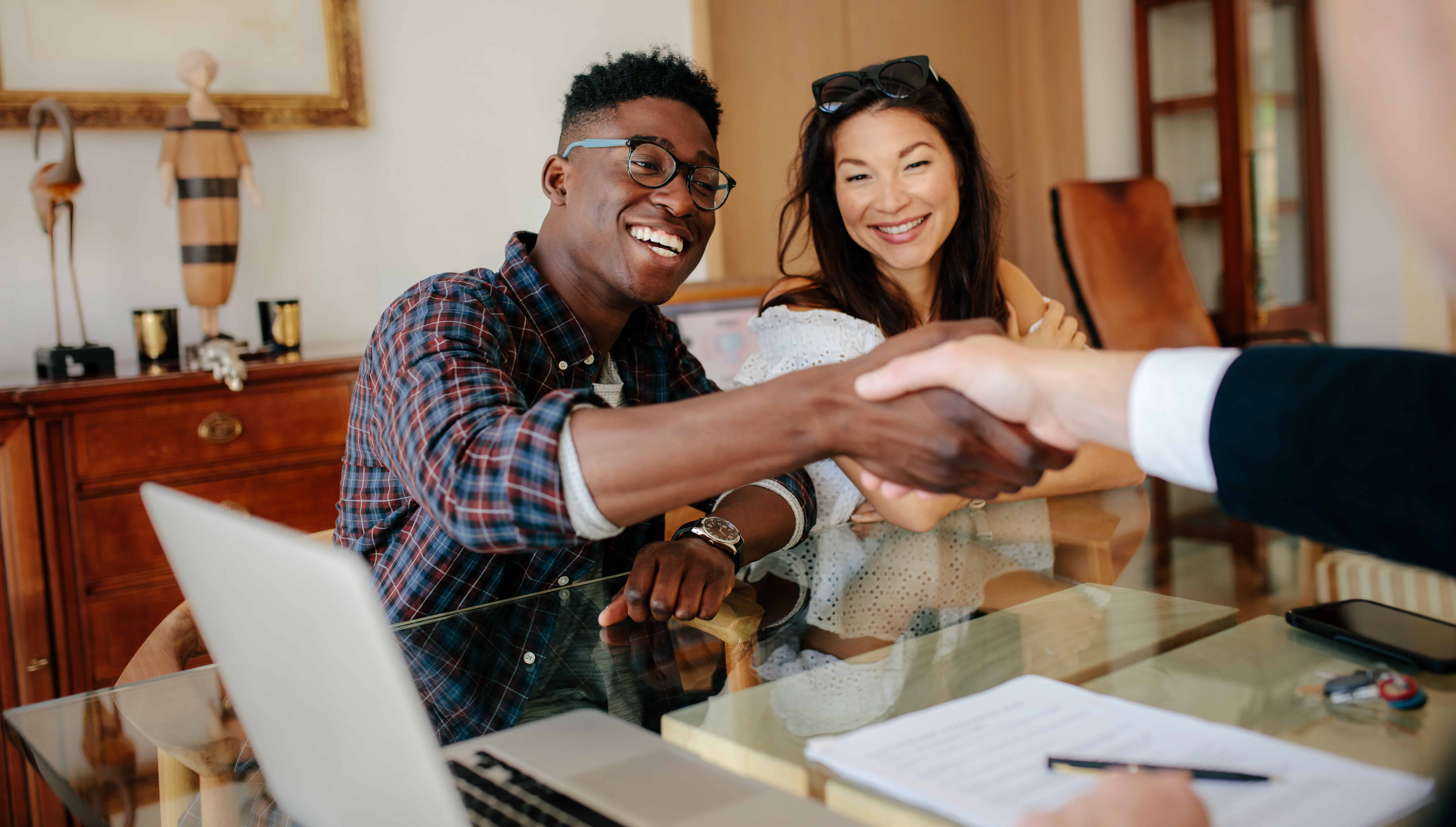 home buyers shaking hands with their real estate agent