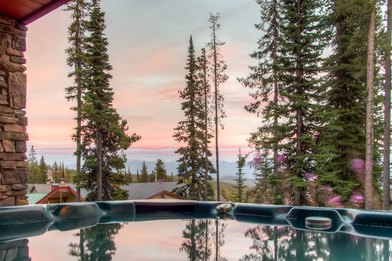 big white cabin with outdoor hot tub