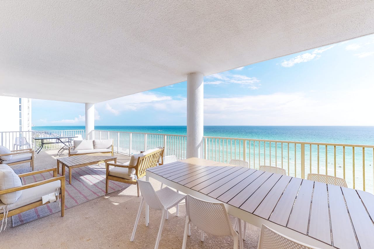 balcony of pcb oceanfront condo decorated with warm wood furnishings and gray tones