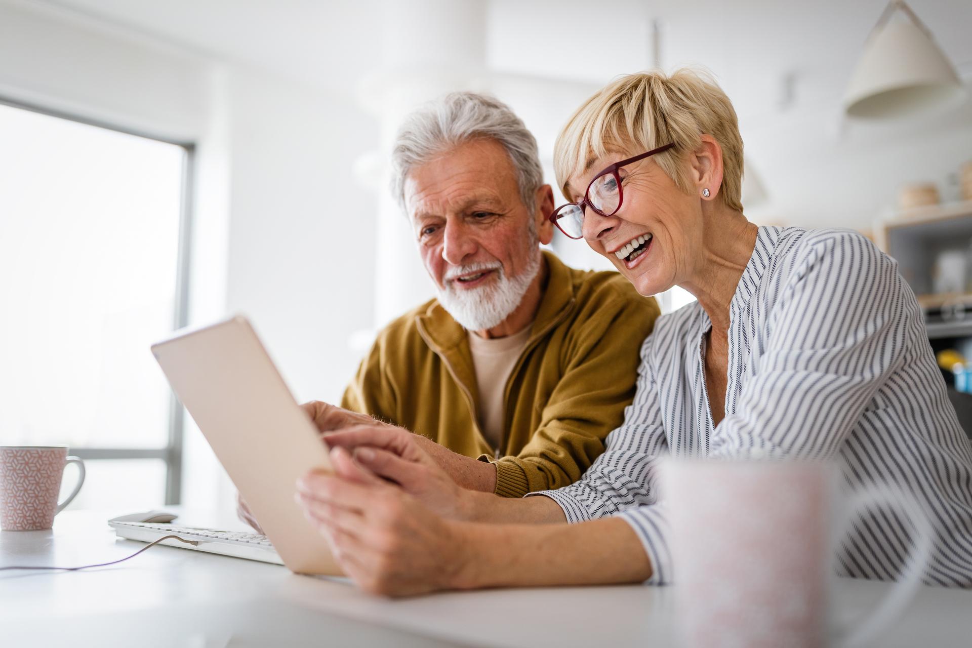 a couple interacts with a tablet while drinking coffee