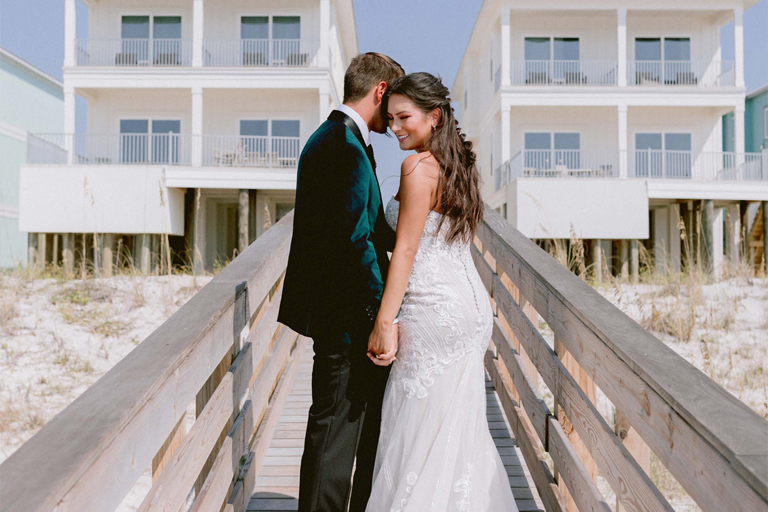 bride and groom standing in front of their wedding-friendly beach house rental