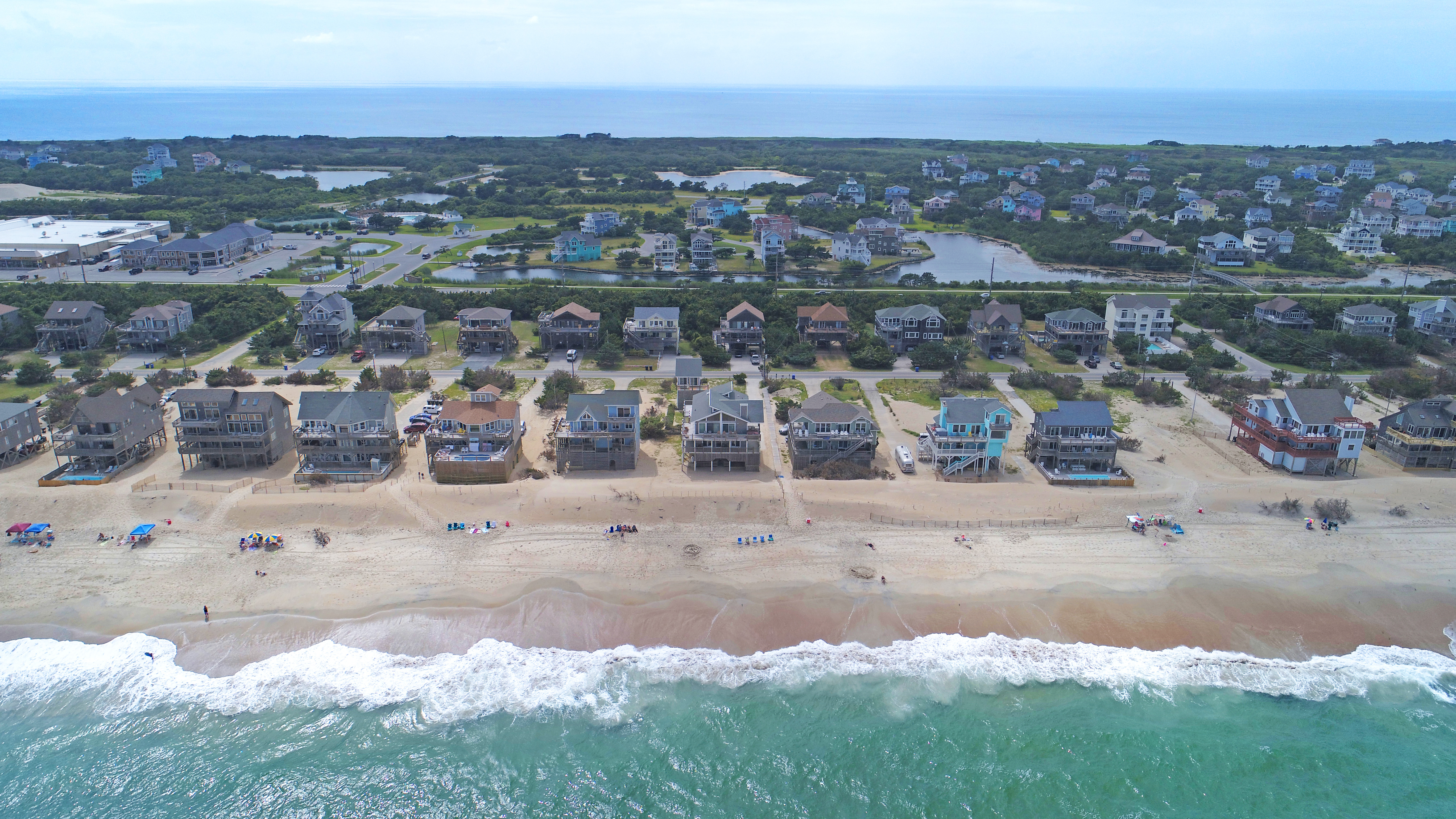 Aerial view of Avon, NC with vacation rentals alongside a beach