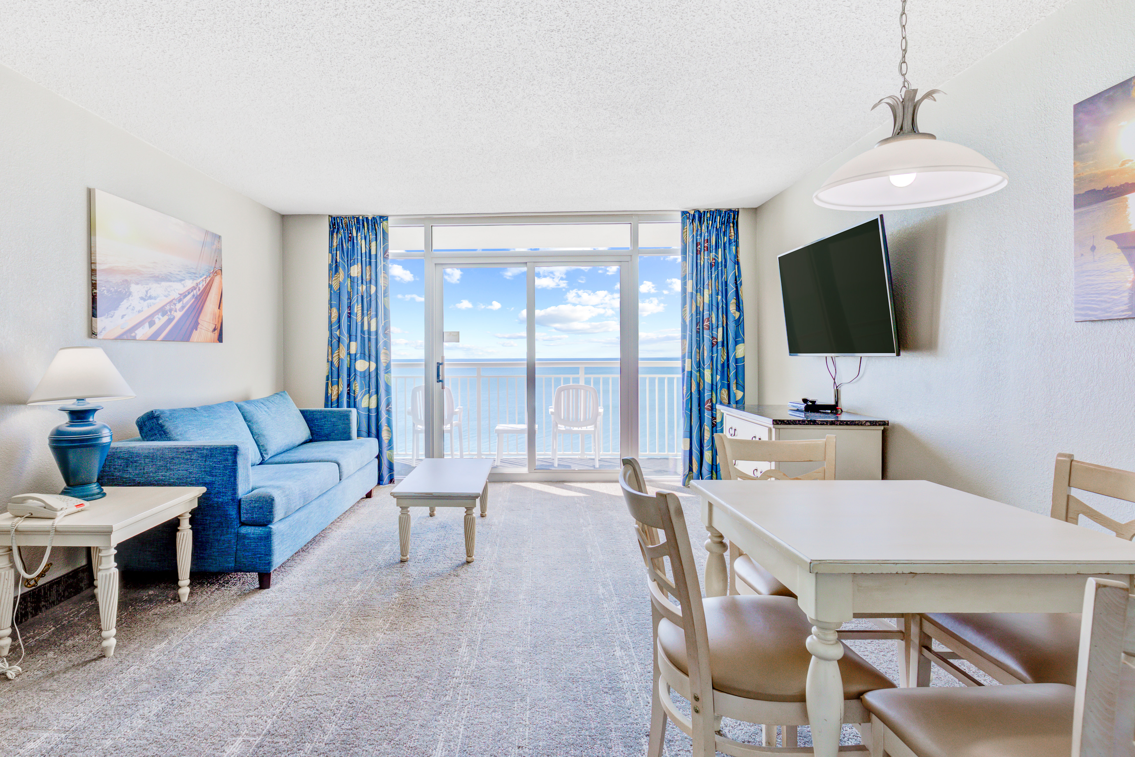 Living room with a balcony facing the ocean at Bay Watch Resort.