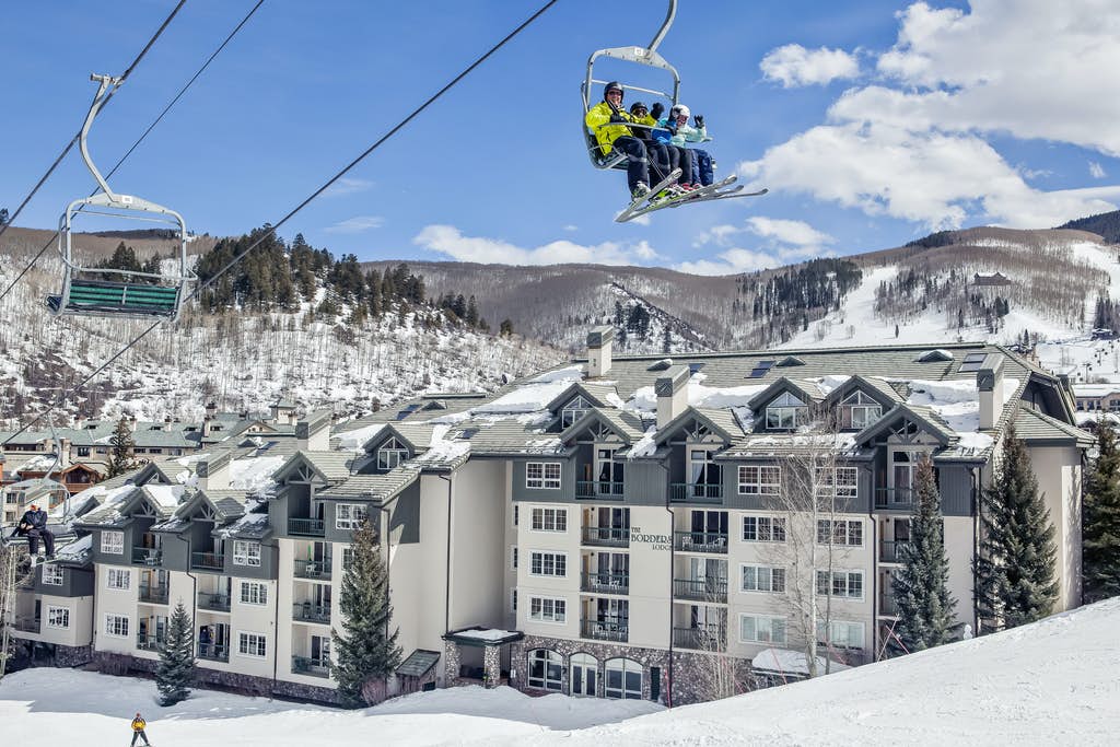 Skiers on a ski lift passing by Borders Lodge