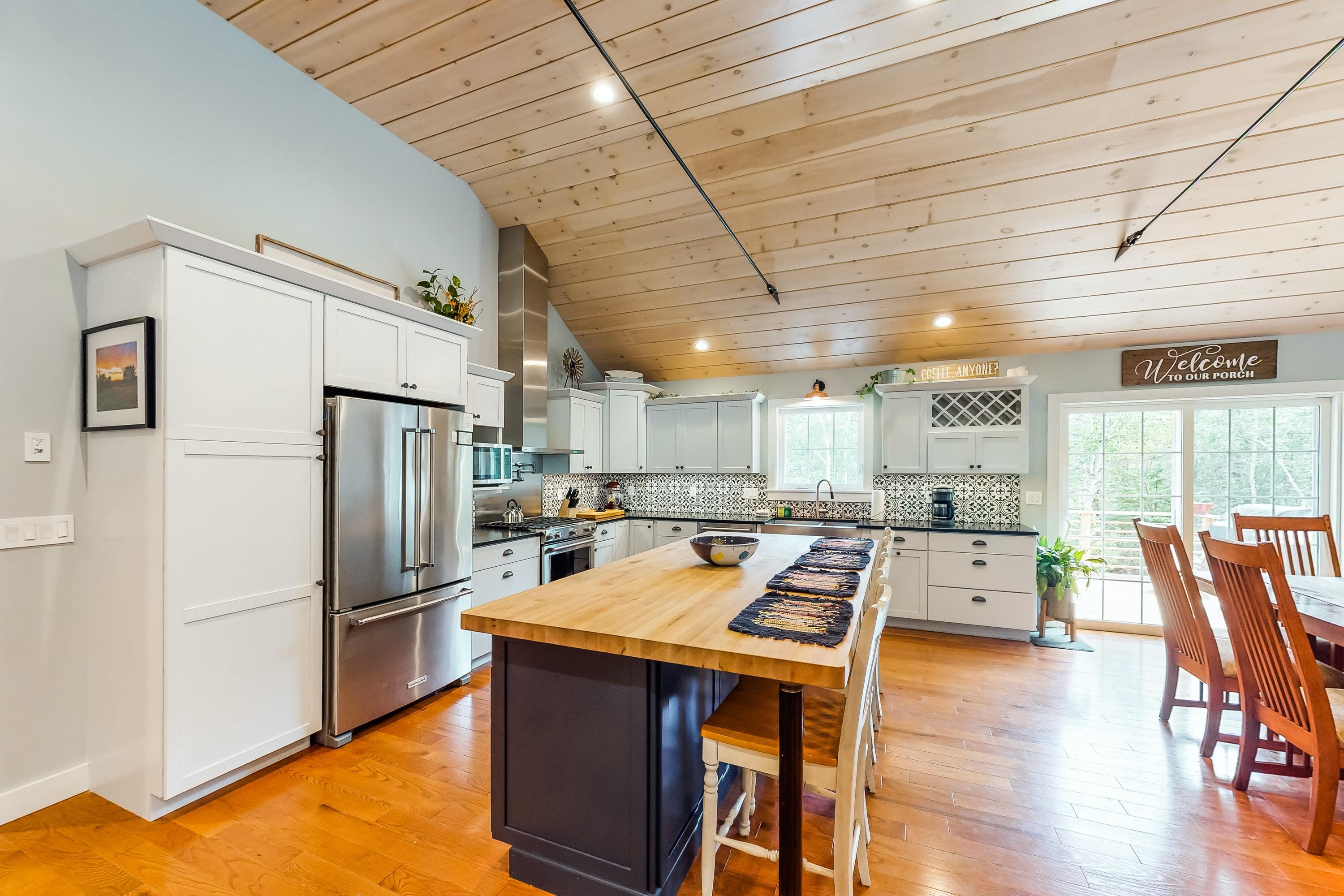 stylish kitchen with tile backsplash, butcher block counters, and stainless steel appliances