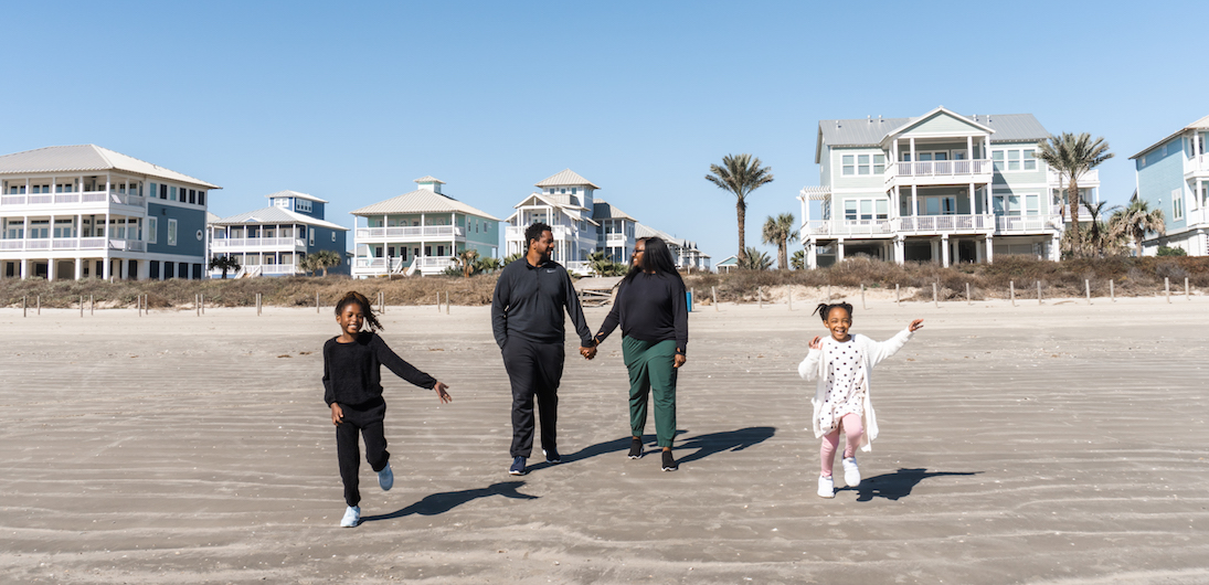 family runs on the beach while on vacation