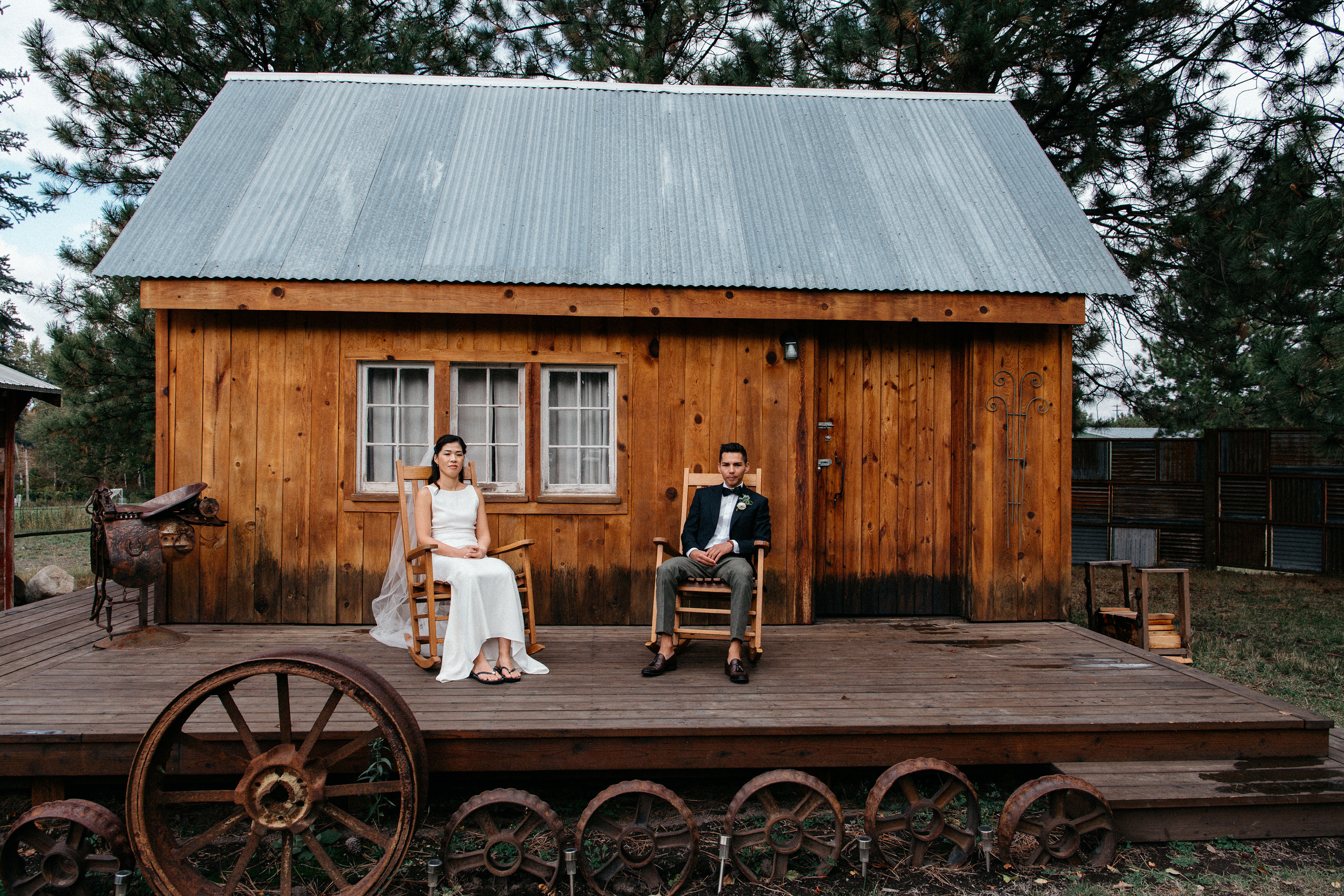 Couple sitting on wooden rocking chairs on a porch.