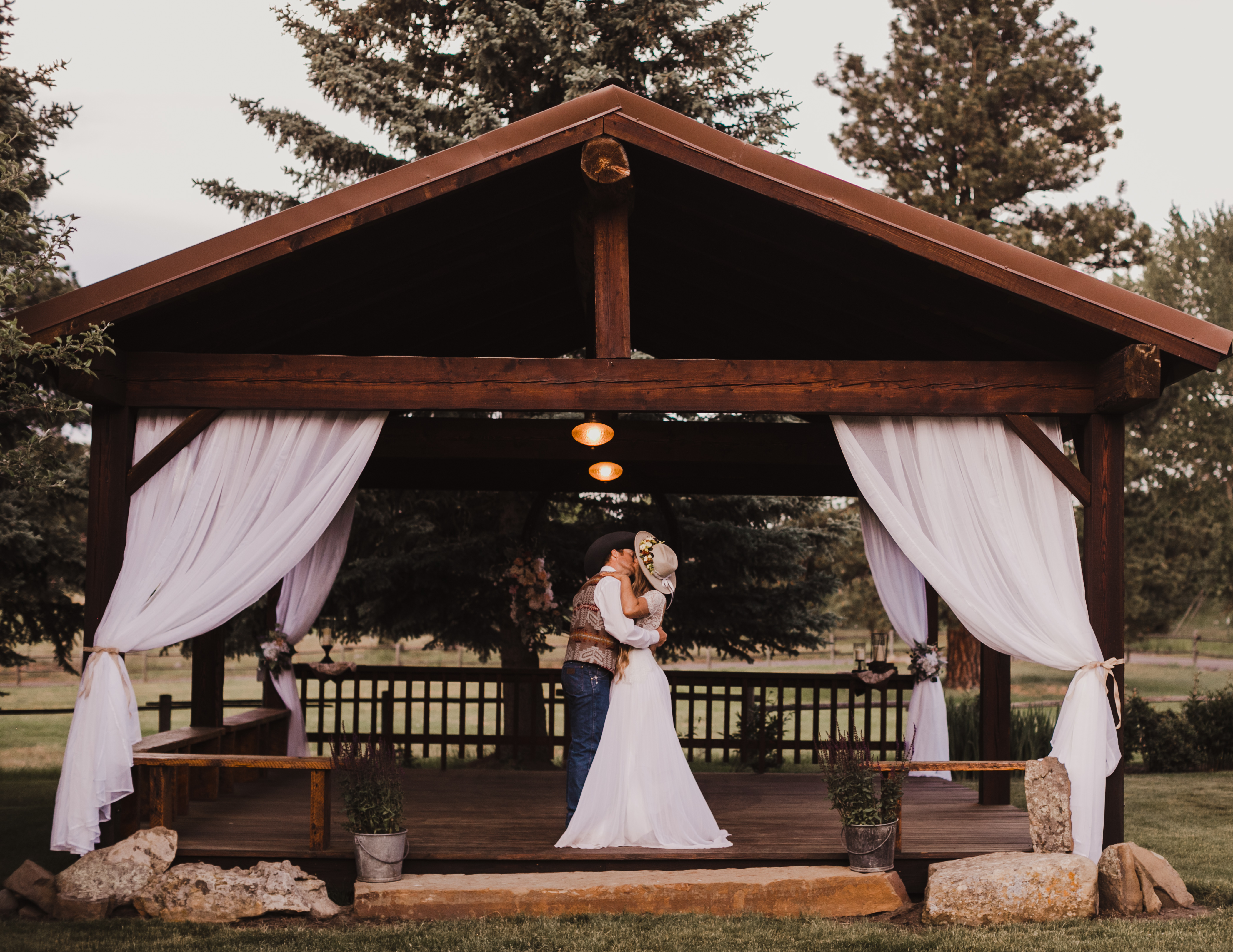 Couple kissing at an outdoor pavilion.