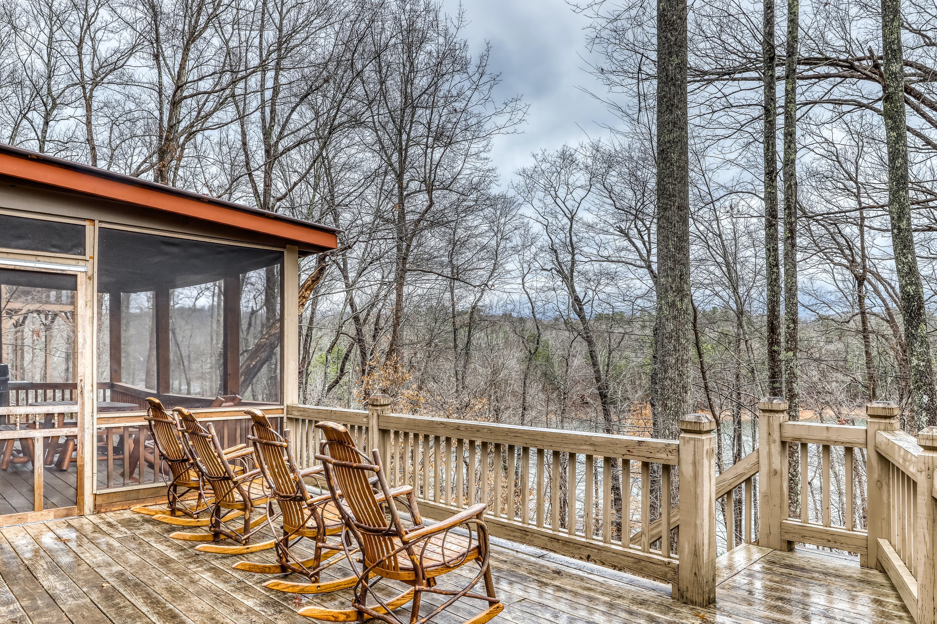 four rocking chairs on a deck face the lake in blue ridge, ga