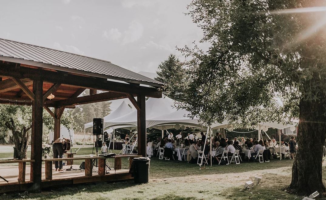Outdoor wedding venue with a pavilion and large covered tent.