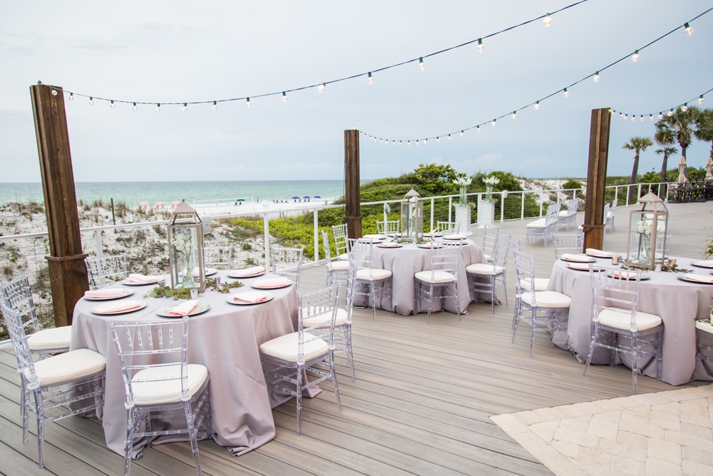 Wedding table and chairs decorated on a large deck with an ocean view
