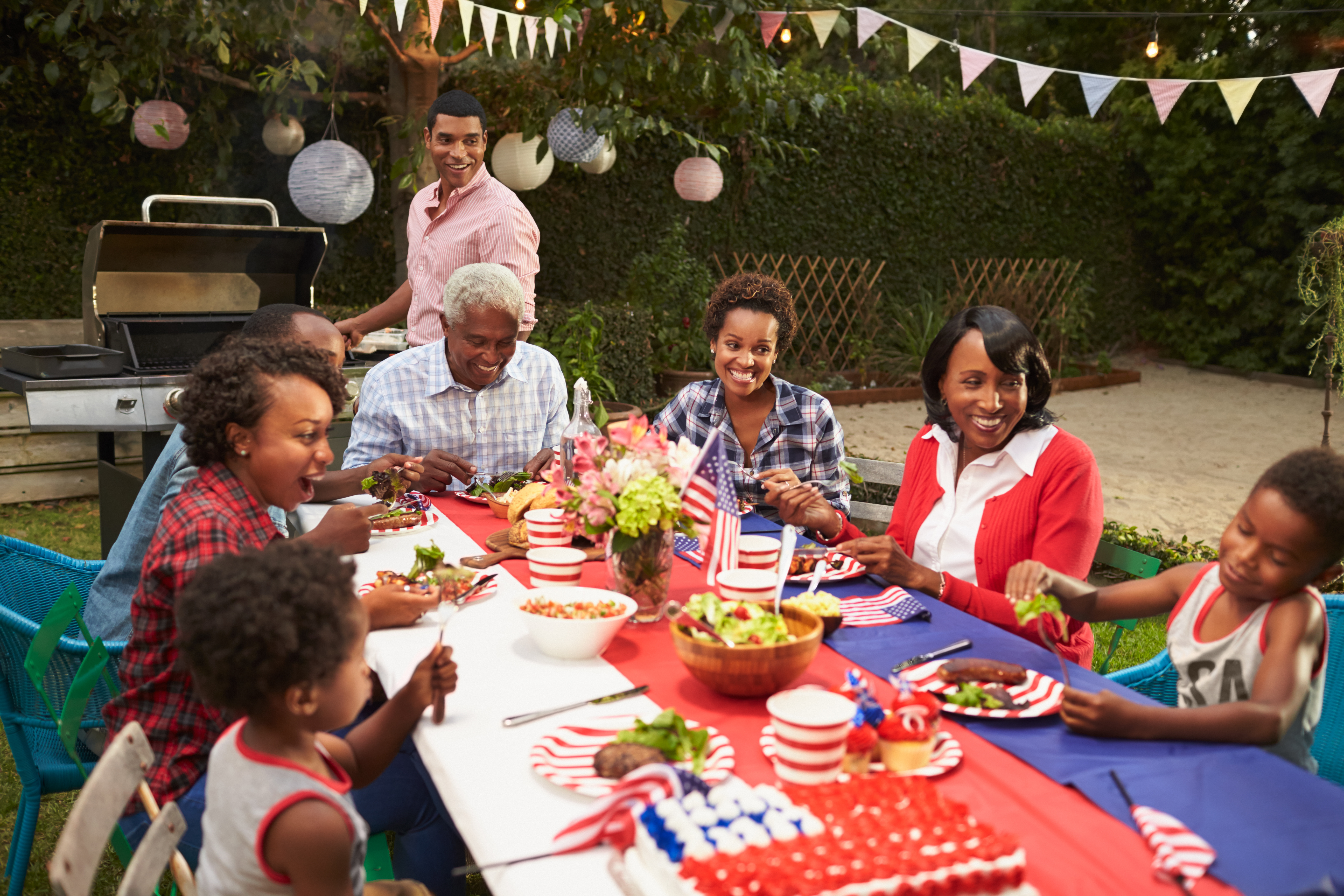 family dines at an outdoor table set up for a party