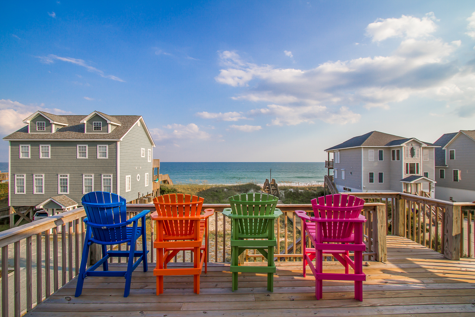 3 chairs at a coastal vacation rental overlooking the beach.