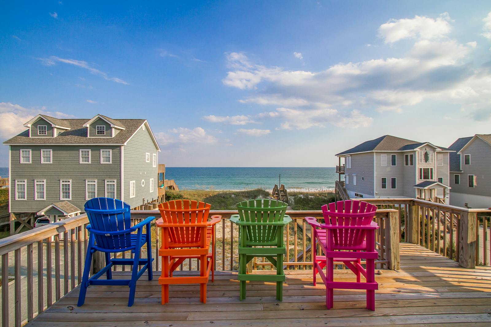 3 chairs at a coastal vacation rental overlooking the beach.