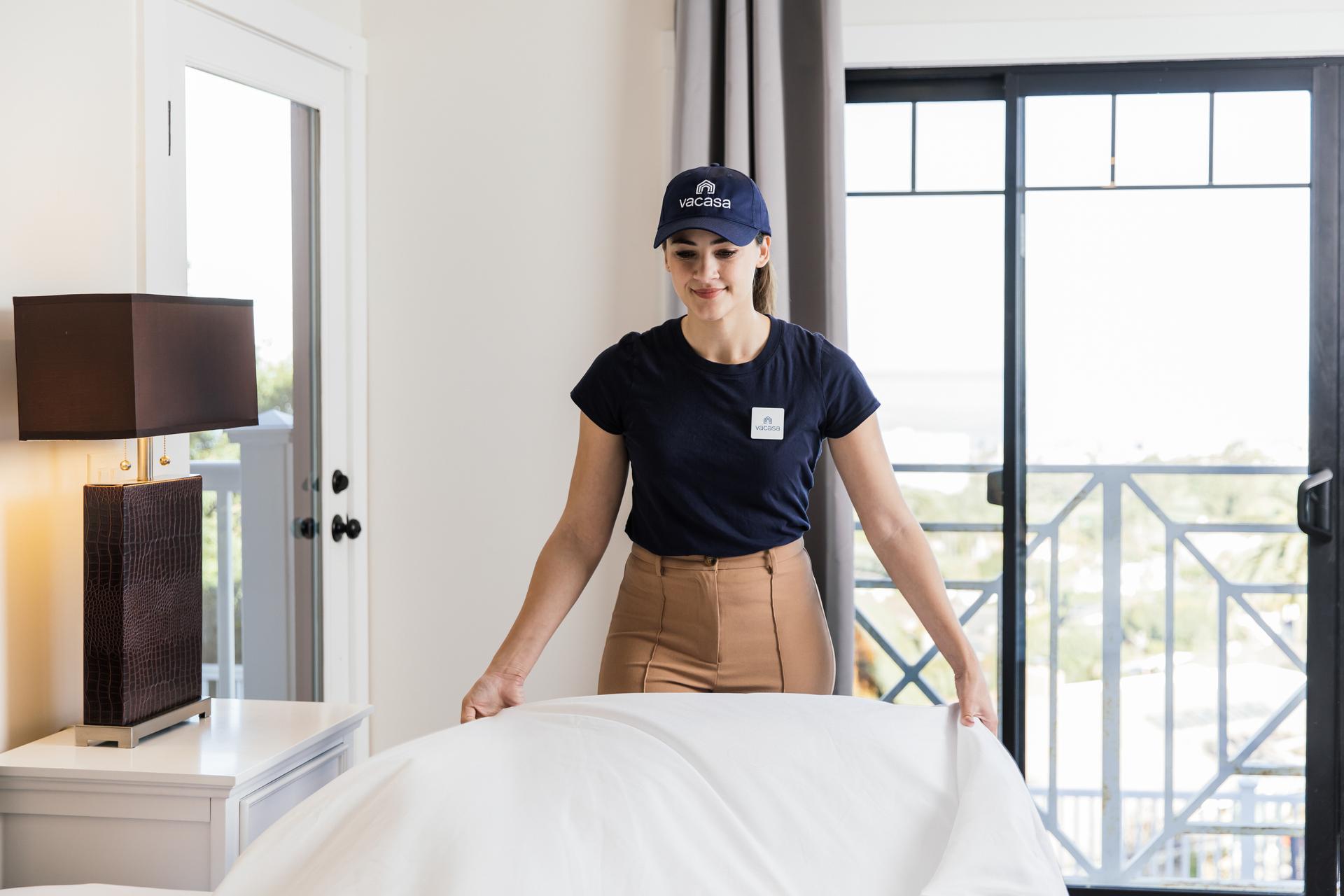 Woman working with Vacasa making a bed.