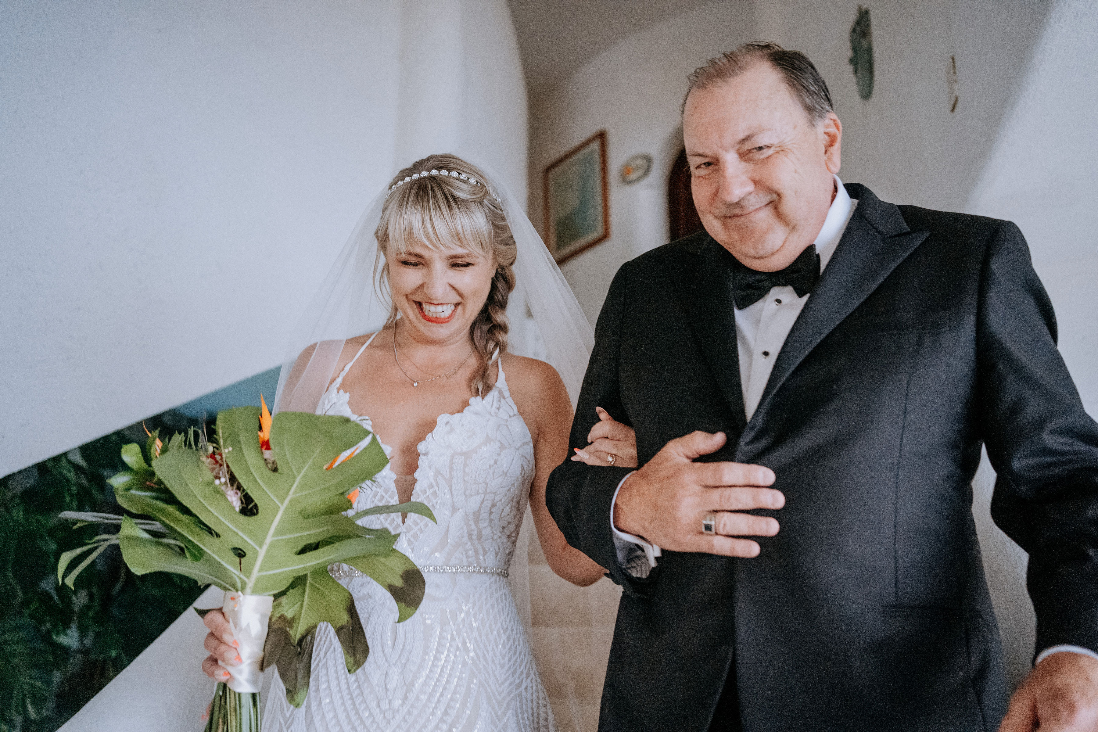 Father and law and a bride walking down stairs.